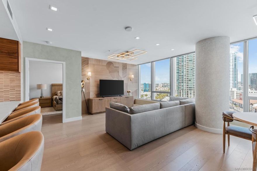 Experience the ultimate in luxury high-rise living at Pacific Gate, San Diego’s iconic waterfront address. Residence 1106 is a stunning 2-bedroom, 2-bath home spanning 1,390 sq. ft., offering an elegant blend of modern design and urban comfort. Expansive glass walls fill the home with natural light, showcasing dynamic city views framed by the downtown skyline.  The open-concept living space features sophisticated upgrades like new wall coverings, fresh paint, and stylish lighting enhancements for added comfort and style. A split-bedroom layout ensures privacy and flexibility, while the private covered terrace extends your living area outdoors. The generous primary suite offers an elegant walk-in closet by California Closet Systems and a spa-inspired bath with heated floors, a walk-in shower, a soaking tub, and an anti-fog electric mirror with an integrated 10” TV screen. Automated blinds and a Smart Home system with climate control add convenience throughout the residence. The second bedroom offers flexibility as a home office or guest retreat.  Residents enjoy unparalleled resort-style amenities including a private yacht share, luxury car fleet, chef concierge, guest suite, state-of-the-art fitness center with sauna and steam room, residents’ lounge, and an on-site restaurant led by a celebrity chef. Ideally located just steps from the bay, this residence is moments from Seaport Village, the Rady Shell, the new RaDD development, and San Diego’s finest dining, shopping, and entertainment.  The first all-glass Super Prime residential tower in San Diego offers an unprecedented waterfront lifestyle with sky-high amenities and picture-postcard views. Directly overlooking the waterfront, the 41-story tower contains an exclusive offering of homes designed by Hirsch Bedner Associates. Renowned New York-based architectural firm Kohn Pedersen Fox (KPF) created a landmark that reimaged the San Diego skyline. The custom-engineered glass walls dynamically reflect the hues of the sky and the Pacific Ocean. Pacific Gate has evolved the San Diego skyline and represents the future of the city. The building is comprised of two-nested curved glass towers that rise as a single column from a three-story ground floor retail podium on the north and west sides of the tower. Because of the building’s curves and exterior glass, Pacific Gate offers a striking viewing experience from every vantage point. Residents arrive home to a beautifully landscaped motor court with a private luxury car fleet, which leads to a double-height lobby with a 24-hour concierge and porter services. Two levels of amenities boast a residents lounge ideal for events and everyday use, the fitness center contains an extensive range of state-of-the-art equipment. Adjacent to the fitness center is the steam and sauna retreats that open up to the fourth-floor pool terrace fitted with poolside cabanas and glass surround.