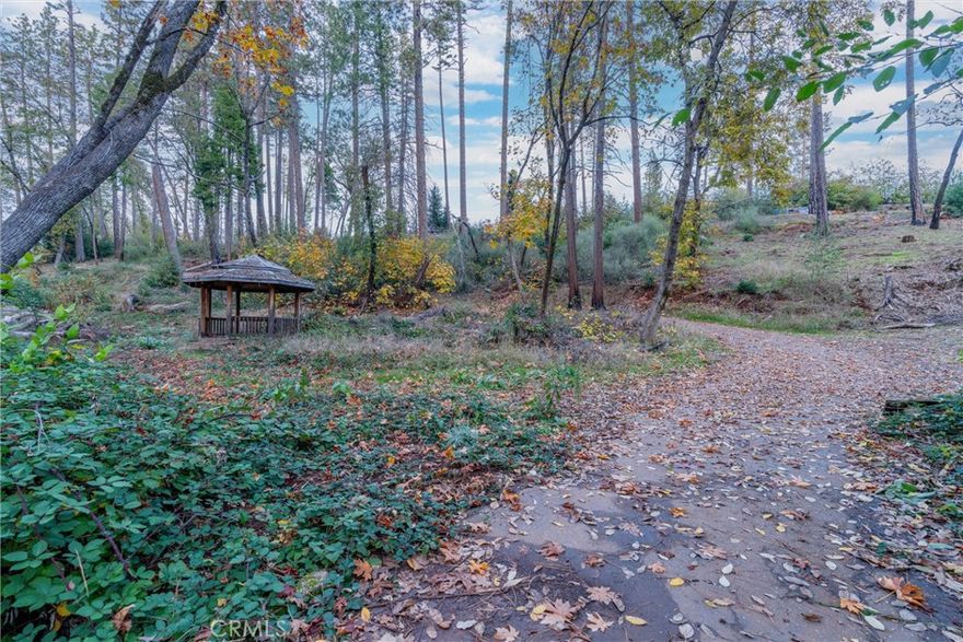 Discover this hidden gem—a 2.32-acre lot nestled beside a year-round creek and shaded by towering pines. The property features a new bridge to the former home site and partially cleared grounds that maintain a natural woodland feel. Underground utilities are installed, and a new gravel path provides easy access. Enjoy the soothing sounds of the creek and the sense of seclusion that makes Paradise so special. Whether you’re ready to rebuild or simply invest in a peaceful piece of land, this property is truly one-of-a-kind.