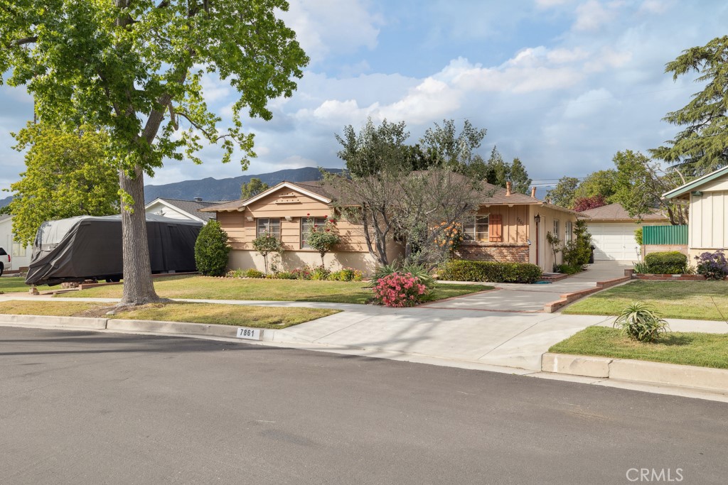 DRASTICALLY REDUCED Charming Ranch-Style Home with Mountain Views in Desirable South Sunland Neighborhood Nestled in the scenic foothills. This charming ranch-style home offers mountain views and timeless appeal. On the market for the first time, this well-maintained 3-bedroom, 2-bathroom residence was built in 1956 and sits on a 6,009 sq ft lot. With 1,480 sq ft of living space. The home features a warm and inviting living room with a cozy fireplace and sliding doors open to a private backyard—perfect for stargazing and entertaining. The spacious formal dining area includes a built-in TV cabinet and offers plenty of room for gatherings. The large kitchen boasts abundant cabinets and storage, a gas cooktop, double ovens, a microwave, and a convenient adjoining laundry room and bathroom. A separate exterior door adds flexibility and ease of access. You will find beautiful hardwood floors throughout the entry, living room, dining room, hallways, and all three generously sized bedrooms. One bedroom features custom-built-in cabinets and shelving, while the primary bedroom offers direct bathroom access, a charming window seat, and expansive windows with views of the lush backyard. Enjoy a well-landscaped front and backyard filled with colorful flowers, creating a serene outdoor escape. Located in a quiet, established neighborhood near top-rated schools, shopping, and transportation, this home also offers proximity to nature and hiking trails, giving you fresh air and convenience all in one. A rare opportunity—buyers are sure to fall in love!