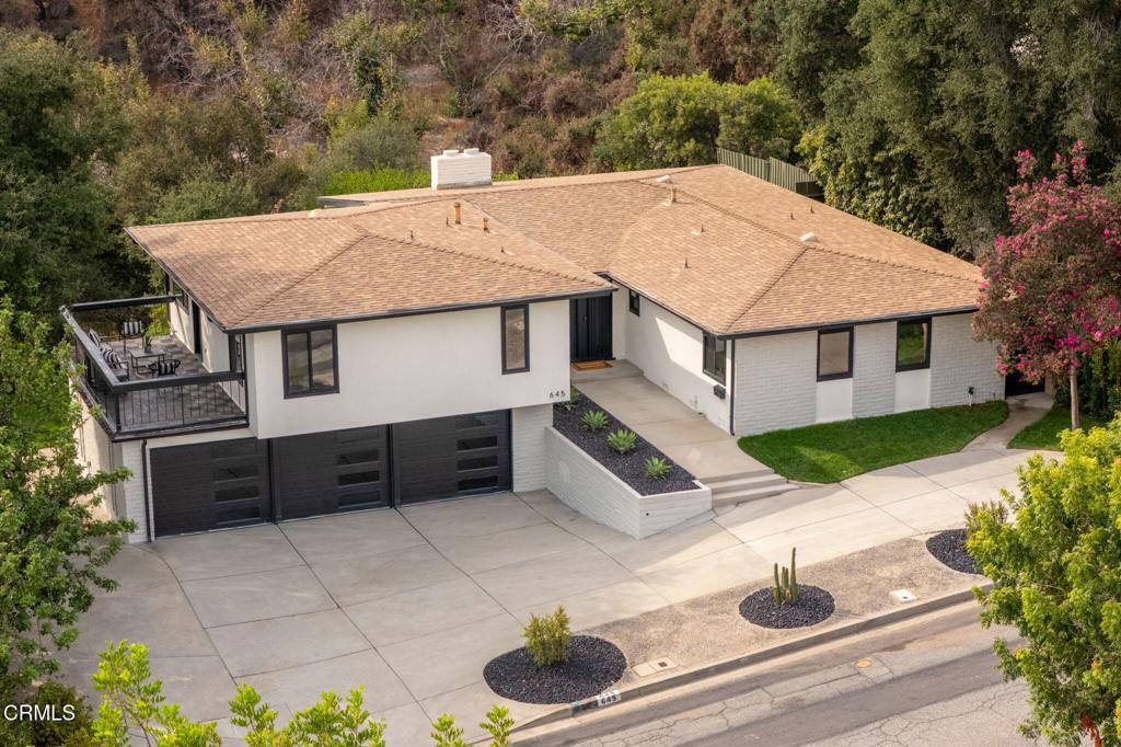 Expertly remodeled and surrounded by natural beauty, 645 Oak Crest Ave is a hilltop dream home with stunning views and a serene setting. Set on a quiet cul-de-sac and totally removed from the hustle and bustle, here you'll savor sun-drenched living areas, walls of glass that bring the outdoors in, and an expansive backyard perfect for both entertaining and play. The first of several showcase spaces is found in the sunken, window-wrapped living room. Here you'll find a 15 ft cathedral ceiling and a dramatic floor-to-ceiling marble statement wall with a sleek linear fireplace. Glass doors open to the deck, creating a perfect indoor-outdoor flow. Nearby, the gorgeous kitchen seems plucked from a design magazine with its elegant quartz waterfall island, stainless appliances, and endless counter space. Whether you're savoring a casual weeknight meal or a joyful dinner feast, the dining room's glass doors offer lush views for an elevated ambiance. Tucked behind the kitchen you'll find two spacious bedrooms sharing a luxurious hallway bath. On the opposite wing of the home, a spacious family room features a wet bar and invites board game nights, Superbowl viewing parties, and movie marathons. While the popcorn pops, enjoy some fresh air on the expansive balcony. At day's end, the generous primary suite is ready to restore your balance with its spa bath where you'll slip into the decadent soaking tub to unwind. Out back, a tiered deck features space for celebrations with dozens of guests. By day, lush plantings wrap the deck in serenity and by night, twinkling city lights turn this space into an enchanting escape. Offering turnkey convenience, beautiful design, and peaceful surroundings, 645 Oak Crest Drive is the complete package!