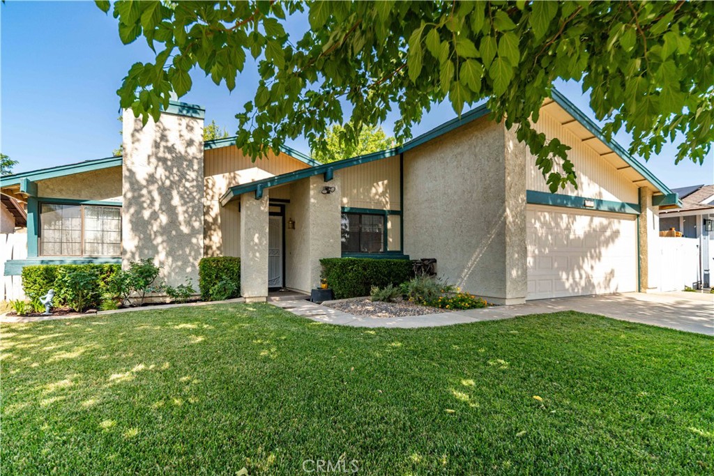 Located in a quiet cul-de-sac, this charming and versatile home offers 2 bedrooms plus a den with a closet—perfect as a potential 3rd bedroom. The inviting living room features a cozy fireplace with an ornate mantel and flows seamlessly into the open dining area and kitchen. Enjoy views of the beautifully landscaped front yard from the kitchen, which includes tile countertops, a gas range, built-in microwave, dishwasher, and refrigerator. The primary bedroom features a walk-in closet and view of the backyard along with ensuite ¾ bath with a tiled shower and glass doors. The spacious guest bedroom also has a view of the backyard and a generous closet space. The den, ideal as a home office or additional bedroom, offers its own closet. Step outside to the large covered patio just off the dining area which is perfect for BBQ's, entertaining family and friends and so much more. The backyard boasts mature trees and offers a blank canvas to create your ideal outdoor retreat. A two-car garage includes built-in shelving and houses the laundry area. Don't miss the chance to make this cozy home your own.