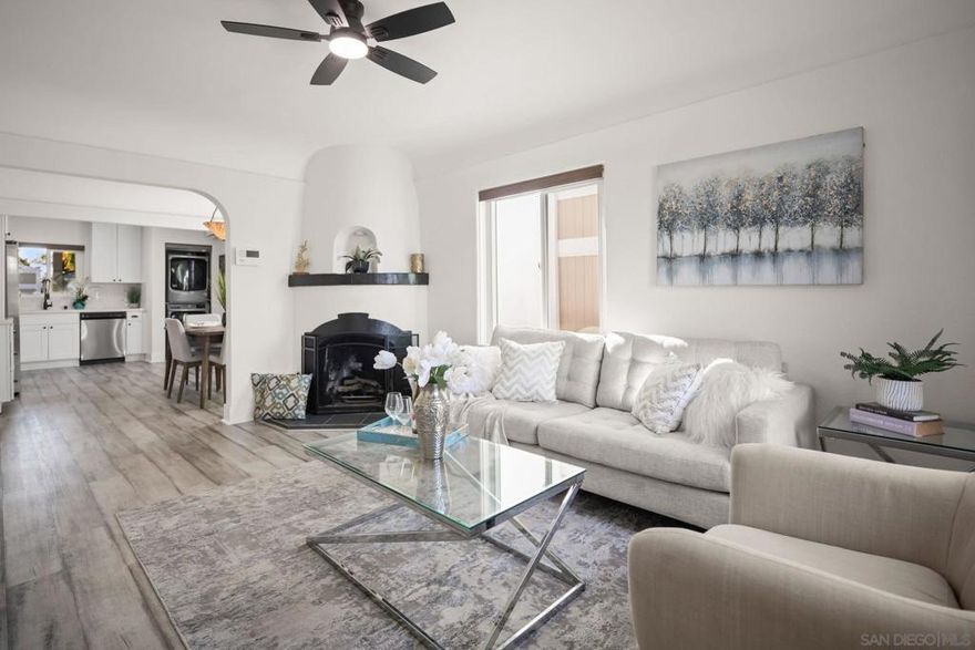 Pride of ownership shines throughout this beautifully maintained Spanish-style home, ideally located just one block from the vibrant Park Boulevard business district. This inviting 2-bedroom, 1-bath home offers 814 square feet of thoughtfully designed living space, blending timeless character with modern updates.  Step inside to discover a bright living room with a cozy gas fireplace and newer ceiling fan, opening seamlessly into the kitchen and dining area for an open-concept feel. The home features newer appliances, dual-pane windows, luxury vinyl plank flooring, and an upgraded bathroom with direct access from both the living area and the primary bedroom.  Enjoy the elevated front patio with charming tile steps leading up from the street and a one-car garage below. The tiered, landscaped front yard and privacy-fenced backyard create serene outdoor spaces—perfect for entertaining, pets, or gardening. Additional highlights include a tankless water heater, updated fencing, and covered patio areas for year-round enjoyment.  Situated just steps from University Heights’ popular cafés, restaurants, boutique shops, grocery stores, Trolley Barn Park, and the Hillcrest Farmers Market, this home offers the perfect combination of charm, convenience, and walkability.