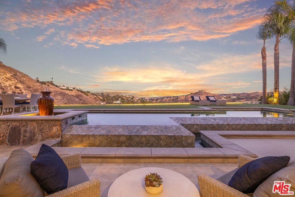 Nestled within the prestigious guard-gated community of The Oaks in Calabasas, this exquisitely remodeled estate redefines luxury living. Boasting 6 bedrooms, all with ensuite baths, and 7.5 total bathrooms, the home is graced with one of the most breathtaking panoramic views in The Oaks, offering a truly unrivaled backdrop to everyday life. This unique residence features an attached 2-bedroom, 2-bathroom casita, an ideal retreat for guests or a private home office. The stunning backyard is an entertainer's dream, complete with a reverse infinity pool, spa, barbecue island, fire pit, and built-in bar. Here, serene days and memorable evenings await, framed by sweeping views and unparalleled privacy. Step through a gated courtyard adorned with a tranquil fountain and into a home of sophisticated elegance. The main house showcases new wide plank white oak hardwood floors, a chef's gourmet kitchen with a Wolf range, and an inviting ambiance that seamlessly blends style and comfort. The expansive primary suite is a sanctuary in itself, with two private balconies overlooking the stunning landscape, a sauna, free-standing tub, a luxurious marble bathroom, and oversized his and hers custom closets. Additional highlights include a three-car garage, motor court, wine cellar, entertainment room with bar, and a prime cul-de-sac location. The home is fully furnished and turnkey with contemporary upgrades. All furnishings are available for purchase (contact agent for more details). This exceptional property is just steps from The Oaks Community Recreation Center, which offers a wealth of amenities, including tennis courts, a large pool, a fitness center, a playground, and more. Located within the highly acclaimed Las Virgenes School District, this is not just a home; it's a lifestyle. A masterpiece of modern elegance, this property offers unparalleled beauty, privacy, and convenience in one of Southern California's most sought-after communities. Welcome to The Oaks.