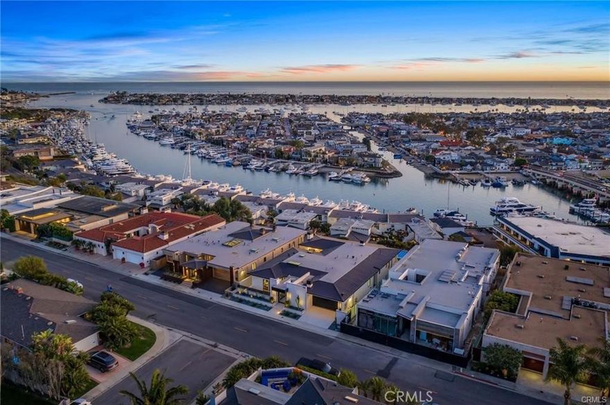 This breathtaking newly-constructed contemporary estate sits in a prime location on the front row of CDM's Irvine Terrace directly overlooking Balboa Island with panoramic ocean views extending from Dana Point to Catalina, and Palos Verdes. With 6 beds, and 8 baths, the 7,709 sq. ft. two-level property features an open floor plan with a modern and inviting living area adjacent to a custom-built bar. The exquisite kitchen comes replete with Italian marble, custom cabinetry, a hidden butler's pantry, and a temperature-controlled glass-enclosed wine cellar. Floor-to-ceiling windows allow abundant natural light throughout the house. The luxurious owner's suite boasts unparalleled views, a fireplace, a spa-like bathroom, and a walk-in closet. Other high-end amenities include a screening room, game room with pool table and bar, spa/gym, Zen atrium, and more. The expansive backyard is perfect for entertaining, with a heated pool and spa, sweeping views of the Marina, outdoor kitchen/BBQ, dining area, and fire pit. Designed by renowned architect Brion Jeannette.
