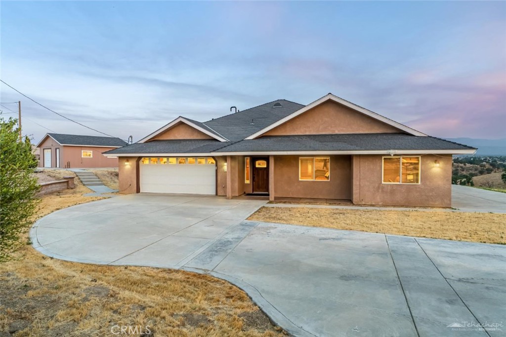 *Live Like Royalty* Welcome to Oak Knolls, located in the hills of Tehachapi which is now one of Southern California's newly accredited wine-growing regions. This peaceful 2.19-acre property offers stunning panoramic views, unforgettable sunrises and sunsets, and the tranquility of country living with four true seasons. Built in 2004, this traditional-style home offers nearly 2,200 sq ft with 4 bedrooms and 2.5 bathrooms. Inside, you'll find a functional floor plan with a spacious great room, pellet stove, and laminate wood flooring throughout the main areas. The kitchen features granite counters, a walk-in pantry, breakfast bar, stainless steel appliances including a newer oven and dishwasher, and the refrigerator is included. The recently remodeled hall bathroom includes a tiled tub/shower combo, updated tile flooring, quartz counters, and stylish raised bowl sinks. The primary suite features a large walk-in closet, soaking tub, dual sinks, a separate shower and offers rear patio access. Enjoy the outdoors on the large, stucco covered patio with lighting, perfect for relaxing or entertaining. The property also includes fruit trees, a utility shed, and a detached 24x24 garage/workshop with 220 electric and available water connection, in addition to the attached 2-car garage with epoxy floors and RV parking. A paid-off solar system adds energy efficiency, while the water softener system and central air conditioning is a great bonus. Located just minutes from town yet offering a private, rural feel, this home is ideal for buyers looking for space, comfort, and scenic beauty. Don't miss the opportunity to own a piece of Tehachapi's country charm with modern upgrades and room to grow. Schedule a showing now!