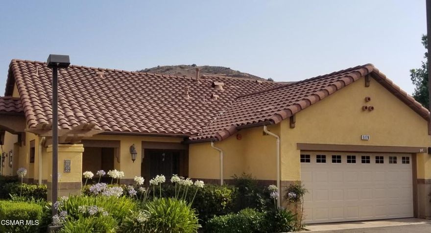 Here is a great opportunity to see a meticulously maintained and upgraded home in a quiet location. One of the largest single-story homes in a senior complex (55 & up) in the City. The home is designed for casual senior living with no steps into the home and a walk-in shower in the primary bathroom with dual sinks. As you enter the home, you will notice beautiful hardwood floors in the hallways, an expansive living room with a decorative fireplace, and formal dining room. High ceilings in the living room and formal dining room makes the home fee much larger than 1,537 sq. ft. Crown molding in all rooms provides a touch of elegance. The open kitchen has built-in stainless-steel appliances, granite counters and recessed lighting. The laundry area is indoors concealed by bi-fold doors. Premium Hunter Douglas window and sliding glass door coverings. From the living room you will see a large covered patio area ensconced by a line of beautiful trees that gives the feeling of a small private compound. This 36-home complex has the feel of an Italian villa. The 2-car garage contains quality built in cabinetry and provides direct access into the home.The Paseo de las Flores senior community includes a swimming pool and an in-ground spa, two large clubhouses, and one with a full kitchen.The Santa Susana Community Park with recreation rooms and a neighborhood shopping center with a supermarket and restaurants nearby.