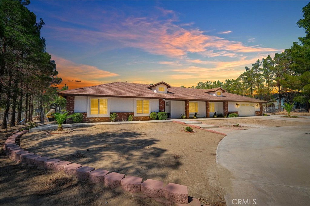 The home you have been looking for is finally here! This beautifully maintained Apple Valley residence sits on a spacious, nearly three quarter acre lot with a set back front yard and a circular driveway that creates instant curb appeal. Masonry style block fencing with integrated lighting adds elegance and nighttime visibility. The fully fenced, level backyard provides ample space for a pool, outdoor living, and entertaining, with convenient rear alley access that is perfect for RVs, trailers, or easy guest entry, adding both convenience and flexibility.
Inside, the home features modern wood look tile flooring, recessed lighting, smart home features, and elegant fandeliers throughout. The bathrooms have been thoughtfully updated with stylish finishes that create a serene, spa like ambiance.
The split floor plan includes an attached garage for easy access, a bonus enclosed sunroom with both interior and backyard access, and an additional multi use bonus area room with interior and private entry that can serve as a home office, guest suite, or fourth bedroom.
Designed for entertaining and comfortable living, the home flows seamlessly to an extra long, two part backyard covered patio that opens at the center to a cozy firepit area, ideal for relaxing evenings under the stars. The cemented, well lit space is perfect for gatherings of any size and provides a private, resort style setting for family and friends.
The tranquil backyard also features a beautifully converted private shed that has been transformed into a glamorous, fully functional retreat with a kitchenette, laundry, and bathroom and sleeping accommodations. This unique space is perfect for hosting guests, private events, or creating a creative studio or personal getaway.
Additional outdoor highlights include several fruit trees, flowering plants, oversized modern planters, and a full irrigation system ready for your landscaping ideas. Upgrades include a premium tankless water heater, a 25-panel solar system installed in 2022 that is through GoodLeap, a smart garage door with camera, and fresh interior and exterior paint. The property is on city sewer and ideally located near schools, shopping, and commuter routes. Bring your RV, enjoy seamless alley access, this home is even ready for your fur babies with a fenced dog run already in place. Experience this serene and stylish oasis designed for modern living and entertaining.