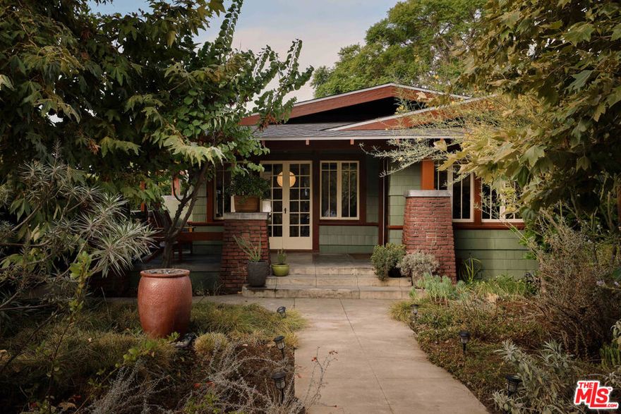 Set behind native landscaping and a spacious front porch, this 1911 Craftsman exudes warmth, history, and charm from the very first moment. Inside, rich original woodwork, wainscoting, built-ins, stained glass, and windows with beautifully wavy glass catch the magical afternoon light, while thoughtful updates provide ease and comfort for modern living. A decorative brick hearth anchors the living room, creating a cozy space that draws people in the kind of home where friends and family naturally gather for holidays and celebrations. The kitchen blends vintage character with modern convenience, featuring marble countertops, a Viking range, and ample space for cooking and entertaining. Three bedrooms and two baths offer flexibility for guests or work-from-home needs, while the primary bathroom includes a luxurious, oversized clawfoot tub. Outdoors, the property unfolds into a private sanctuary. An orchard row of mature fruit trees, including pineapple guava, apple, persimmon, apricot, lemon, avocado, and some of the sweetest oranges, surrounds terraced gardens with space for vegetables, shaded patios, and an expansive deck for entertaining under the trees. Solar panels add efficiency, and a two-car detached garage with side street access, along with a long driveway, offer both practicality and potential for future ADU use. The location balances quiet neighborhood charm with easy access to local amenities just one block from groceries, close to the Glassell Park pool/ recreation center, and Rio de Los Angeles State Park, and a short ride to the Frogtown LA River path. Local favorites like Dunsmoor, Lemon Poppy Kitchen, and The Grant are nearby, while Atwater Village, Highland Park, and Silver Lake are just minutes away. This rare Craftsman retreat brings history, community, and nature together in perfect harmony.