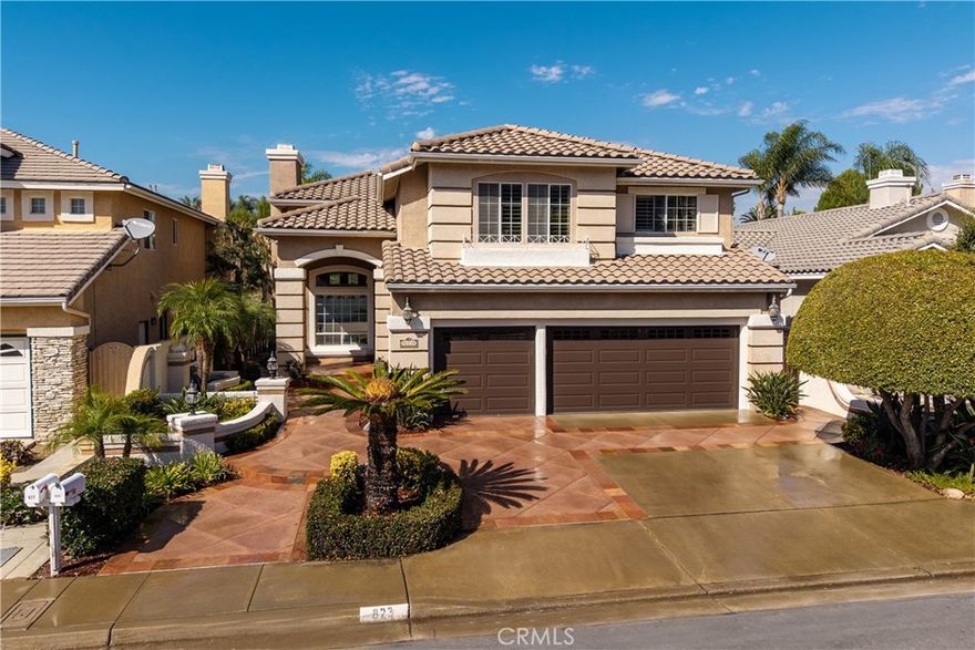 823 Cottontail Lane, Anaheim Hills 5 Bedrooms | 3 Baths | 3-Car Garage | Canyon View|
Welcome to this beautifully upgraded view home in the hills of Anaheim. From the moment you arrive, the impressive curb appeal stands out with a front courtyard highlighted by a large fountain, and a colored concrete driveway accented with slate.
Enter through elegant custom iron double doors into a welcoming foyer with fossilized Portuguese limestone floors. To the left, the formal living room features a custom fireplace mantel, mirrored wall, and crown molding. The adjoining formal dining room offers wood shutters and a sliding glass door that opens to the backyard patio, creating a seamless indoor/outdoor flow.
The upgraded kitchen is a chef’s delight with rich cabinetry, granite counters, tile backsplash, and an oversized island with bar seating and a five-burner cooktop. High-end Thermador appliances include three ovens and a microwave. Recessed and pendant lighting illuminate the space. The kitchen opens to the inviting family room complete with a brick fireplace, custom mantel, and a granite-topped wet bar—perfect for entertaining.
The main level also includes a bedroom and an upgraded three-quarter bath, plus a convenient laundry room with sink.
Upstairs, the spacious primary suite features double door entry, a retreat, ceiling fan, walk-in closet, and a private balcony to take in the serene canyon views. A double-sided fireplace warms both the retreat and the luxurious primary bath with dual vanities, upgraded cabinetry, recessed lighting, chandelier, a jetted tub, separate shower, and private toilet room. Three additional bedrooms—one currently used as a bonus room—share a well-appointed hall bath with dual sinks and a tub/shower combination.
Step outside to a stunning backyard designed for entertaining, complete with an alumawood patio cover, outdoor fireplace, chandelier, mounted TV, BBQ island, and a soothing fountain—all set against a tranquil canyon backdrop.
Additional features include wood shutters on all windows, a whole-house water softener and filtration system, and dual-zone heating and air conditioning for year-round comfort. Close to award winning schools, shopping, restaurants
and freeways