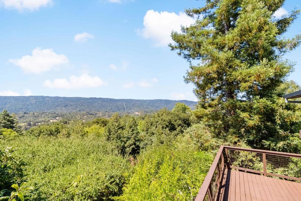 Emeerald Hills Masterpiece- Totally remodeled in. the last 6 years. Over 4,000 sq ft on a private 0.65-acre lot with panoramic views from Crystal Springs to the Bay and bridges beyond. Featuring a new roof with solar + EV charging, upgraded windows, Spalted Maple floors, 300-amp panel, gas meter, redwood siding, and stone/stucco accents. The gourmet granite kitchen with Thermador appliances opens to the living/dining areas and expansive views via European-style collapsing doors. The luxurious primary suite includes a walk-in closet, office/sitting area, and spa-like stone bath. All bathrooms are finished in marble or granite. Enjoy four levels of decks, a gazebo, rainwater tanks, mature fruit trees, rare botanicals, and in-law potential. The lower level (a former art gallery) offers endless possibilities. Additional highlights include a gated driveway, pass-through carport, and original + new permitted plans. Minutes to trails, Hwy 280, and Woodsideturnkey elegance meets modern comfort in one of the areas most coveted locations.