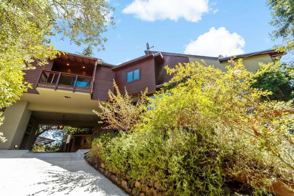 Tucked away in the coveted Emerald Hills neighborhood, this beautiful artisanal home offers over 4,000 square feet of living space on a serene and private 0.65-acre lot. With sweeping views of the mountain range, the open floor plan is perfect for modern living and entertaining. A gourmet kitchen flows seamlessly into the living and dining areas, all framed by European-style collapsing doors that invite the outdoors in. The expansive primary suite includes space for a sitting area or office, a walk-in closet, and a luxurious stone bathroom with tranquil views of mountains and the reservoir. A second bedroom, additional office, and a private deck complete the main level, leading up to a rooftop deck with panoramic vistas. Downstairs, the spacious open area that was once used as an art gallery offers endless possibilities for reimagining. The grounds are rich with mature fruit trees and rare botanical species. A gated driveway and pass-through carport to the yard offer both convenience and privacy. Just minutes to walking and horse trails, the 280 exit and the town of Woodside.