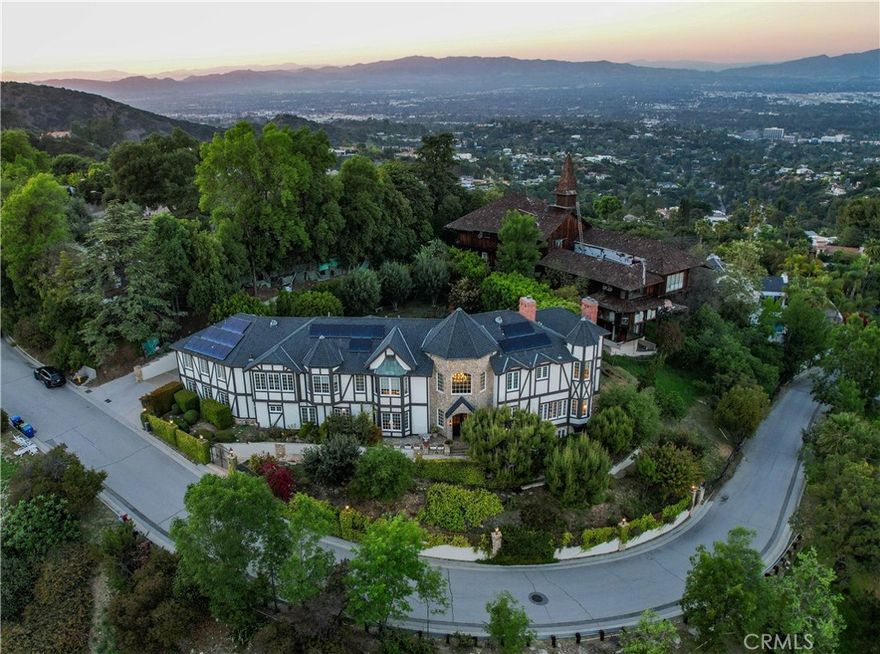Welcome to this breathtaking Brentwood estate offering sweeping panoramic views of the city, valley, and surrounding mountains. Nestled in private gated community with easy access into the Valley or Westside. As you step inside, an impressive two-story foyer sets the tone for its grand scale entertaining, complemented by a voluminous family room anchored by its central fireplace and walk-up wet bar, separate formal living room with view windows and dining room designed for elegant gatherings. At the heart of the home sits the culinary kitchen outfitted with center island cooktop, dual refrigeration, indoor BBQ, loads of custom cabinetry, along with a separate breakfast room with poolside views. Encompassing seven suites, which includes its elegant primary bedroom featuring a private lounge with fireplace, private balcony, spa-inspired bath, grand walk-in closet and serene vistas. Upstairs, enjoy a versatile and massive media/game room perfect for relaxation or a private theater. A separate guest apartment provides ideal accommodations for visitors, while an indoor sports court delivers year-round recreation. Step out and relax in the ultra-private rear yard, which is an entertainer’s dream with expansive patio retreats, a grassy play area, sparkling swimmers pool, along with multiple lounging and dining venues. Three car garage, paid solar system, sauna, library/office, the list is just endless...dont miss this rare offering blending extraordinary privacy, wonderful amenities, and world-class vistas into one unforgettable property.