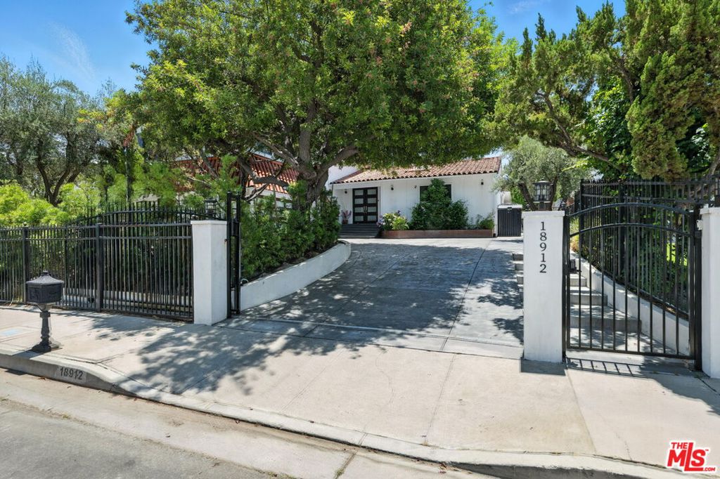 Experience elevated California living in this turnkey, gated transitional modern estate, ideally located South of the Boulevard in Tarzana. Sitting on an expansive 18,000+ sq ft lot and perched above a tranquil golf course, this beautifully renovated home offers uninterrupted golf course views, exceptional privacy, and flexible living spaces. The main residence features a spacious formal living area, a large family room with glass doors opening to the exterior, a formal dining area, and a chef's kitchen with Thermador appliances and custom cabinetry. Enjoy the rare convenience of two primary suites one upstairs with a private balcony and another downstairs with a private bathroom and large walk-in closet, ideal for multigenerational living or guests. The property includes two guesthouses, perfect for visitors, a home office, or your own private home gym. Outdoor amenities include 4 car driveway parking, a sparkling pool, built-in BBQ, enclosed patio, and gazebo ideal for year-round entertaining in a peaceful setting. Just minutes from top-rated schools, shopping, dining, and Braemar Country Club, this is a rare opportunity to own a modern estate with premium golf course frontage in one of Tarzana's most sought-after locations.