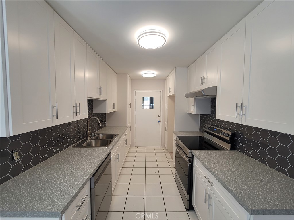 Spacious and bright 2-bedroom, 2-bath condo featuring an open living and dining area with wood-style flooring, mirrored accent wall, and sliding glass doors leading to a private balcony. The updated galley kitchen offers modern cabinetry, sleek countertops, and stainless steel appliances. Bedrooms are generously sized with ample closet space, and the unit includes central air/heat and abundant natural light throughout. Conveniently located near shopping, dining, and major freeways in a well-maintained community with great amenities.