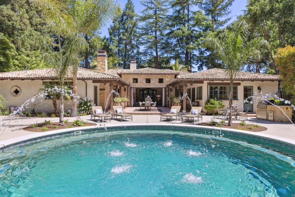 Inspired by California Mission architecture this impeccable custom home is set on a rare estate lot. Every detail is solid and exquisite from antique French roof tiles to hand scraped walnut floors. Grand scale living room with beamed ceiling and yellow osage stone fireplace opens onto central courtyard with expansive rear grounds, pool and spa, entertaining pavilion and 1bd/1ba guest house. Designed to live as a single story home the main level features en-suite bedrooms, an office with full bath, a separate family room and a large chef's kitchen with sumptuous limestone counters and sun-filled breakfast room. Amenities placed conveniently on lower level with elevator access - 2 additional bedrooms with separate entrances, theater, spa bath, dry sauna, 4 car showplace garage, wine cellar and tasting room. Generator, security with video surveillance, whole house water filtration. Incredible opportunity for custom estate living with the convenience and easy lifestyle of downtown living.
