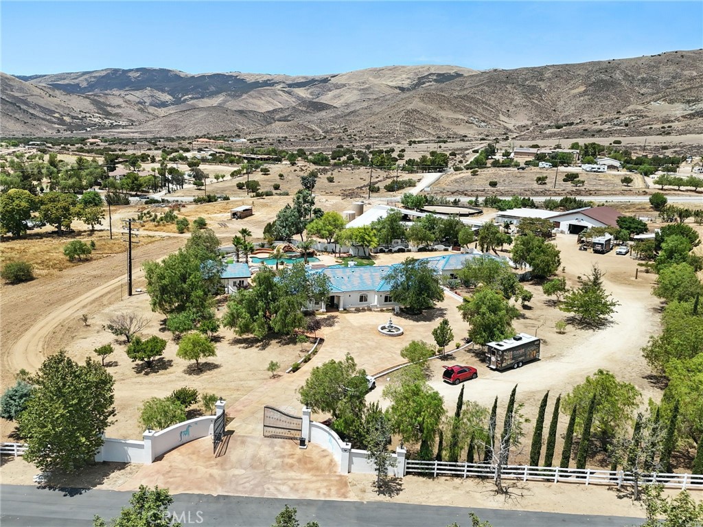 Welcome to this single-story, exceptional 5+ acre property located in the highly desirable Southwind Estates. This private, gated residence offers 5 bedrooms, 3 bathrooms, and a sparkling pool with a serene water fall, built-in barbecue surrounded by lush fruit and palm trees.
Equestrian and agricultural enthusiasts will appreciate the 6,000 sq. ft. barn, 9,500 sq. ft. mare stalls, and a fully equipped greenhouse. The outdoor kitchen is perfect for entertaining, while the entire property is secured with sturdy 2.5" rail metal pipe fencing reinforced with stud wire.
Enjoy complete self-sufficiency with an OWNED WELL producing 10–12 gallons per minute, a 500-gallon owned propane tank, and owned solar for energy efficiency.
A rare combination of privacy, functionality, and resort-style living—ready for your lifestyle or business needs.