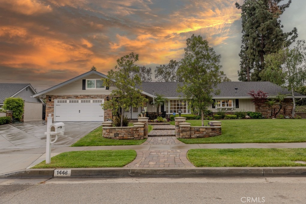Welcome to 1448 W Domingo Rd in Fullerton, a beautifully upgraded single-story home in the highly desirable Sunny Hills neighborhood. This home sits on a private lot just under half an acre, offering space, comfort, and incredible outdoor living. From the moment you arrive, you’re welcomed by paver walkways, a double-door entry, and charming stacked stone accents. Inside is a foyer that opens to a spacious living room with a large bay window providing great natural lighting, wood flooring, and recessed lighting. The kitchen is tastefully updated with granite counters, an island, stainless steel appliances, upgraded cabinetry, recessed lights, a bay window, and a pantry. The dining area has a ceiling fan and French doors with operable side panels opening to the backyard. To the left of the entry, the large family room has a brick fireplace, recessed lighting, and another set of French doors with side windows that open, creating great indoor-outdoor flow. The covered patio is an entertainer's dream. Both ends of the patio feature recessed lights and dual ceiling fans. It’s wired for a wall-mounted TV and set up for outdoor entertaining. The stainless steel barbecue can connect to a gas line and sits near the paver-lined entertaining area. The pool and spa include a diving board and multiple waterfalls that flow into the pool. The spacious yard also includes a large grass area and is surrounded by mature trees for enhanced privacy and relaxation. All bedrooms and living spaces have wood flooring, while the kitchen, bathrooms, and dining area feature large tile flooring. The primary bedroom has double-door entry, a walk-in closet, plantation shutters, and a ceiling fan. The remodeled bathroom features granite counters, custom cabinetry, recessed lights, and a walk-in tiled shower. The guest bathroom has dual sinks, custom cabinetry, and a tiled shower combo. Not included in the square footage is an upstairs bonus area with an office nook and open media space. The finished two-car garage has direct access and epoxy flooring. A wide driveway provides room for multiple cars. All windows have been replaced, solar with 33 panels is paid off, the electrical panels have been updated, and the home is in excellent condition. Zoned for some of Fullerton’s top-rated schools including Laguna Rd and Sunny Hills, this location is ideal for anyone seeking access to top-tier education. Rare chance to own this beautiful home in one of the best neighborhoods in the city.