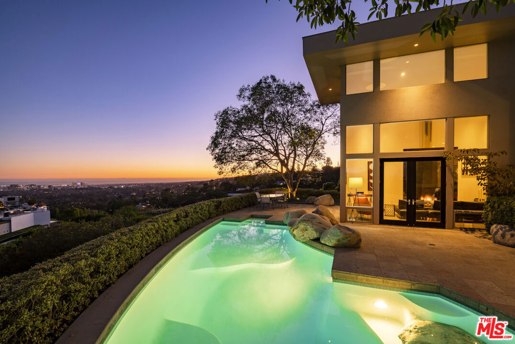 Through the expansive gate and up the long, private driveway, uncover this renovated, enchanting contemporary estate nestled on nearly an acre of prime land. Positioned atop a scenic promontory lot, this secluded haven offers unparalleled privacy and views. Boasting exquisite furnishings, this exclusive retreat features 5 bedrooms, an office, a library, a spacious living room perfect for entertaining, a fully equipped gym complete with a spa and steam room, and a professional indoor sports court. With ample parking including a generous motor court and four covered spaces, as well as a stunning pool that offers sweeping views from Downtown to the Ocean, this property is just minutes away from Sunset Blvd. The architectural design showcases soaring ceilings, picturesque windows that flood the space with natural light, and tasteful finishes throughout. This extraordinary gem is sure to captivate the most discerning of buyers.