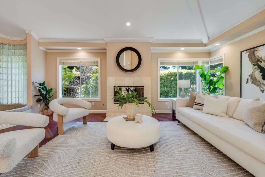 Custom home with amazing views, featuring 4 bed, 3.5 bath, plus an office, offering 3,010 sq. ft. of living space on a 7,612 sq. ft lot. A sun-drenched entrance, announced by a stately classical column, leads to the formal entertaining spaces set over hardwood floors. Soaring ceilings as you enter the living room with fireplace open to dining area with vaulted ceiling, & built-in wet bar. A private office/den boasts its own fireplace. The open-concept great room combines a chef's kitchen, dining nook, & family room with floor-to-ceiling built-in bookshelves. French doors open to a balcony with hillside views. Primary suite is a spectacular retreat with dramatic vaulted ceilings, skylights & walk-in closet. Sliding doors open to a balcony with expansive views. Updated spa-like ensuite is beautifully appointed with double sinks, freestanding tub, & tiled stall shower. Spacious secondary bed & full bath located on the second floor. The lower level features a spacious living area, two additional beds, full bath & access to a ground-level paver patio. Located near Blackberry Farm, McClellan Ranch, and Fremont Older Open Space Preserve, this home combines picturesque views, easy outdoor access, and top-rated Cupertino schools for the best of Silicon Valley living.