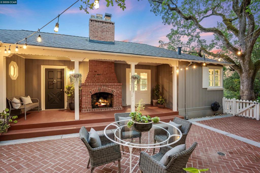 Charming 1939 bungalow with hillside views, stylish updates, and thoughtful character throughout. Surrounded by mature oaks, this light-filled home blends original architectural details with modern upgrades. A brick courtyard with café lights and an outdoor fireplace sets the tone for relaxed outdoor living. Inside, enjoy hardwood floors, a showpiece fireplace with copper detailing, and oversized windows that frame the view. The remodeled kitchen features quartz countertops, stainless appliances, custom cabinetry, and a sunny breakfast nook. The spacious primary suite opens to a private deck and includes a large bonus room with built-ins and French doors, ideal for a home office, studio, or lounge. A full bath with dual sinks and a walk-in shower sits nearby. Two additional bedrooms and another updated bathroom complete the layout. Set on nearly half an acre, the property offers multiple areas to relax, garden, or explore future possibilities. Architectural plans for a detached ADU are included. Peaceful and private, this special home combines vintage charm with everyday comfort in a beautiful natural setting.