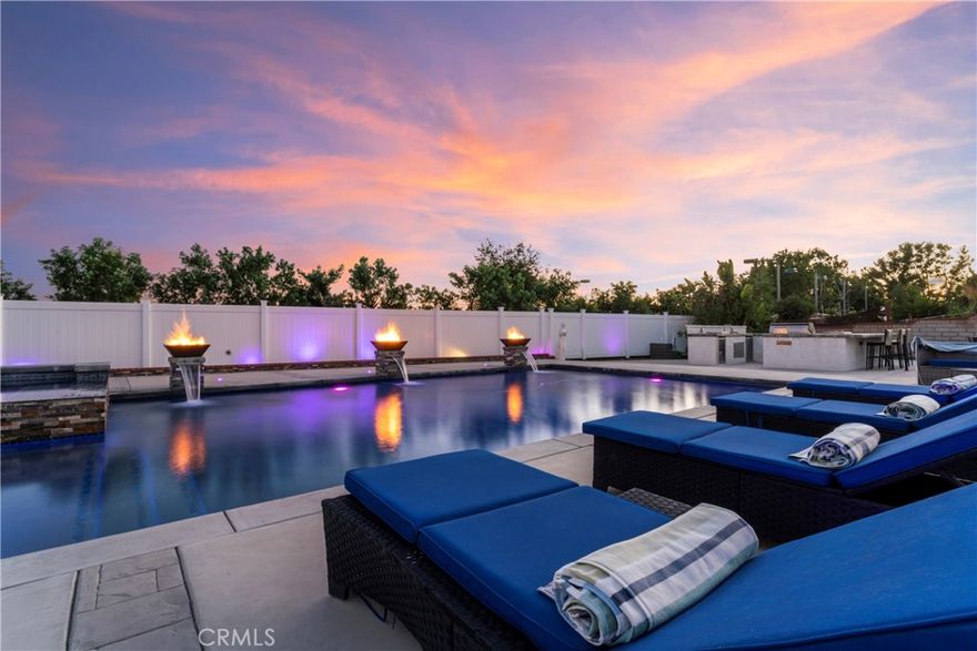 Experience elevated living in this exquisitely remodeled smart home perched in the highly sought-after Deer Creek neighborhood. With breathtaking panoramic city lights views, this luxe estate blends cutting-edge technology with resort-style amenities—perfect for both entertaining and everyday comfort.

Completely renovated from top to bottom within the last four years, the home showcases designer finishes including quartz countertops with a waterfall island, smart switches, upgraded appliances, crown molding, and undercabinet lighting. Including five en-suites, the master suite is a true retreat, featuring a spa-like wet room with a freestanding tub, bidet, multiple showerheads, and dual steam units.

Step outside into a backyard oasis where you will find the Olympic-sized black-bottom pool and spa dazzle with fireballs and waterfalls. The expansive built-in barbecue and outdoor kitchen includes a flat-top grill, refrigerator, ice chest, and wraparound countertops—all set up for effortless hosting with natural gas connections. Enjoy evenings around the fire pit or unwind in the two-story pool house with A/C and laminate wood flooring.

Other standout features include: Solar panels with a new electrical panel, dual A/C units, digitally controlled outdoor lighting with multicolor options, smart home automation with Alexa control for garage, lighting, HVAC, and more, a three-car garage with overhead storage, a separate second septic system for the lower level, dramatic vaulted ceilings, LED touchscreen mirrors, and a striking glass chandelier in the entry.

From thoughtful details to grand-scale entertaining potential, this one-of-a-kind home offers luxury, convenience, and stunning views in one of Rancho Cucamonga’s most coveted communities.