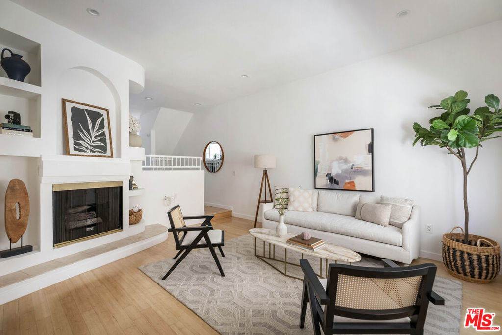 Soaring ceilings, glorious skylights, and abundant natural light define this stunning 2-bedroom, 2.5-bath North Hollywood town home, which also happens to be in a small, pet-friendly building. Step into the inviting open-concept living area anchored by a cozy fireplace, with beautiful built-ins, warm bamboo floors, recessed lighting, and a charming powder room. A split-level design leads to the fully renovated kitchen featuring stainless steel appliances, gorgeous white quartz countertops, custom cabinetry, tile floors, and an eat-in dining area with plenty of storage. On the lower level, enjoy direct access from the subterranean garage (two designated parking spots) into your spacious utility room complete with side-by-side washer/dryer, new industrial sink, and additional cabinets for storage and supplies. Upstairs, both generously-apportioned bedrooms offer fully updated en suite bathrooms and access to private outdoor areas. The show-stopping primary suite boasts soaring ceilings, a bright loft space perfect for a home office, shower/tub combo in the bathroom, large walk-in closet, and a spacious private rooftop deck with sweeping neighborhood views the perfect place to wake up with a cup of coffee or relax and unwind at the end of the day. New central AC (2024) and tasteful upgrades throughout make this turnkey home a rare find just moments from vibrant dining including Lawless Brew Co, Granville, Pit fire Pizza, The Federal, Fat Dog, and Republic of Pie, plus shops, theaters, the studios, the Chandler Bike Path, Metro Red Line, and easy freeway access to the 101, 134, and 170. A wonderful opportunity awaits!
