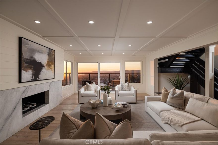 An elevated coastal sanctuary set atop a commanding bluff in Southeast San Clemente, 303 E Avenida Cordoba is a rare coastal estate where timeless design meets sweeping ocean grandeur. Framed by unobstructed vistas of the Pacific Ocean, Catalina Island, San Clemente Pier, Dana Point Harbor, and city lights, this six-bedroom, four-and-a-half-bath residence offers an exceptional living experience defined by space, serenity, and panoramic beauty. A gated entry leads to an expansive 12,390 square foot homesite, where a thoughtfully landscaped front courtyard creates a striking first impression and a perfect setting for refined outdoor entertaining. To the rear, an oversized deck and lounge area capture spectacular year-round sunsets while ocean breezes and lush surroundings create a tranquil outdoor retreat. Inside, the home's versatile layout spans two levels, featuring three bedrooms and two-and-a-half baths on the main floor, and three bedrooms with two additional baths upstairs. Four of the six bedrooms enjoy captivating ocean views. The primary suite is a tranquil retreat, with vaulted tongue-and-groove ceilings, exposed beams, a cozy fireplace, custom walk-in closet, and a spa-inspired bath—all framed by sweeping coastal panoramas. Every detail has been thoughtfully reimagined: from highly designed baths and bespoke vanities to custom wood paneling, premium appliances, new LED lighting, and curated fixtures. New custom carpet, full interior and exterior paint, and epoxy-coated garage floors enhance the home’s elevated aesthetic. The lush grounds offer privacy and calm, with mature trees, new drought-tolerant landscaping, decomposed granite gardens, a flat grassy pad, and a new irrigation system. A truly ideal setting for outdoor enjoyment and al-fresco dining, the yard also presents ample space for future expansion or personalization. The oversized garage—with a third bay for a golf cart or collector car—pairs with a long driveway to offer generous parking for residents and guests alike. Ideally located just minutes from San Clemente’s celebrated beaches, boutique shops, vibrant dining, and world-class surf, this exceptional residence blends relaxed California luxury with a rare sense of retreat. Graciously shown by appointment.
