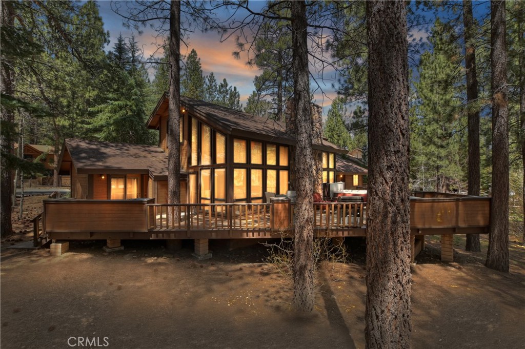 Welcome to your stunning custom mountain retreat nestled in the desired Heavenly Valley Estates of Big Bear Lake ~ This beautifully crafted home emanates rustic alpine charm and is located just minutes from Snow Summit and the lake ~ The modern upgrades make it an ideal getaway or high-performing investment property ~ Step inside to an expansive open-concept layout, highlighted by vaulted tongue-and-groove ceilings, a dramatic floor-to-ceiling rock fireplace, and oversized windows that frame peaceful forest views ~ A dedicated game area and wet bar add to the home’s entertaining appeal ~ The chef’s kitchen is both functional and stylish, with stone countertops, and stainless-steel appliances, that flows seamlessly into a spacious dining area, perfect for hosting friends and family ~ This home features three main-level bedrooms and two bathrooms, while the upper-level loft serves as a fourth sleeping area and private suite ~ The lofted primary retreat includes a serene overlook of the great room below, plus a luxurious en-suite bathroom featuring a steam shower—perfect for relaxing after a day on the slopes ~ Outside, nearly 1,000 square feet of deck space provides the ultimate in mountain living ~ Enjoy built-in seating, a large dining and BBQ area, and a hot tub, all surrounded by mature trees and mountain air ~ Other highlights include a separate mudroom/laundry area ideal for stashing ski gear, and a detached playhouse offering extra charm and storage ~ The home sits on a large, treed lot that offers both privacy and space ~ Whether you're seeking a peaceful second home or a proven short-term rental, this home is Big Bear living at its finest. Schedule your showing today!