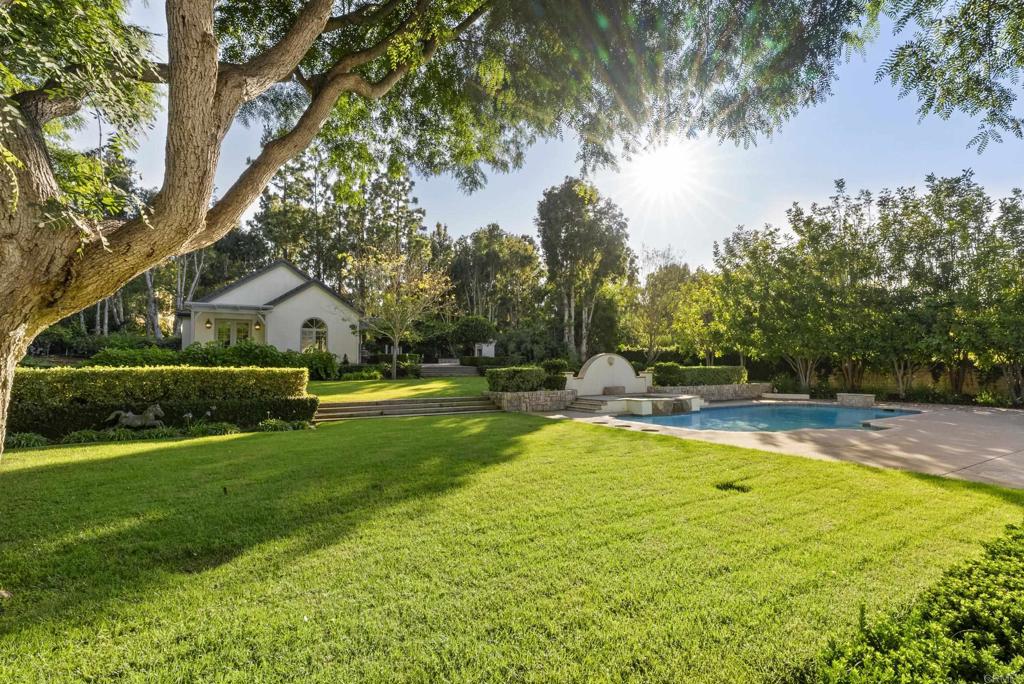 Within the prestigious gates of Fairbanks Ranch, this charming single-story estate offers approximately 5,771 square feet of refined living space. In the main residence, five bedrooms, five full baths, and one half bath are thoughtfully designed for both large-scale entertaining and intimate daily life, while a detached 1 bedroom, 1 bathroom guest house offers added comfort and versatility. Set on roughly one acre, the property is a meticulous blend of spectacular gardens with specimen trees and plantings. The property enjoys tranquil territorial views and a natural sense of privacy. Expansive living areas transition effortlessly to the outdoors, creating a seamless connection to the surrounding landscape. A three-car garage offers generous parking, while the home’s location provides access to acclaimed schools, upscale dining, and the coastal lifestyle for which Rancho Santa Fe is renowned.