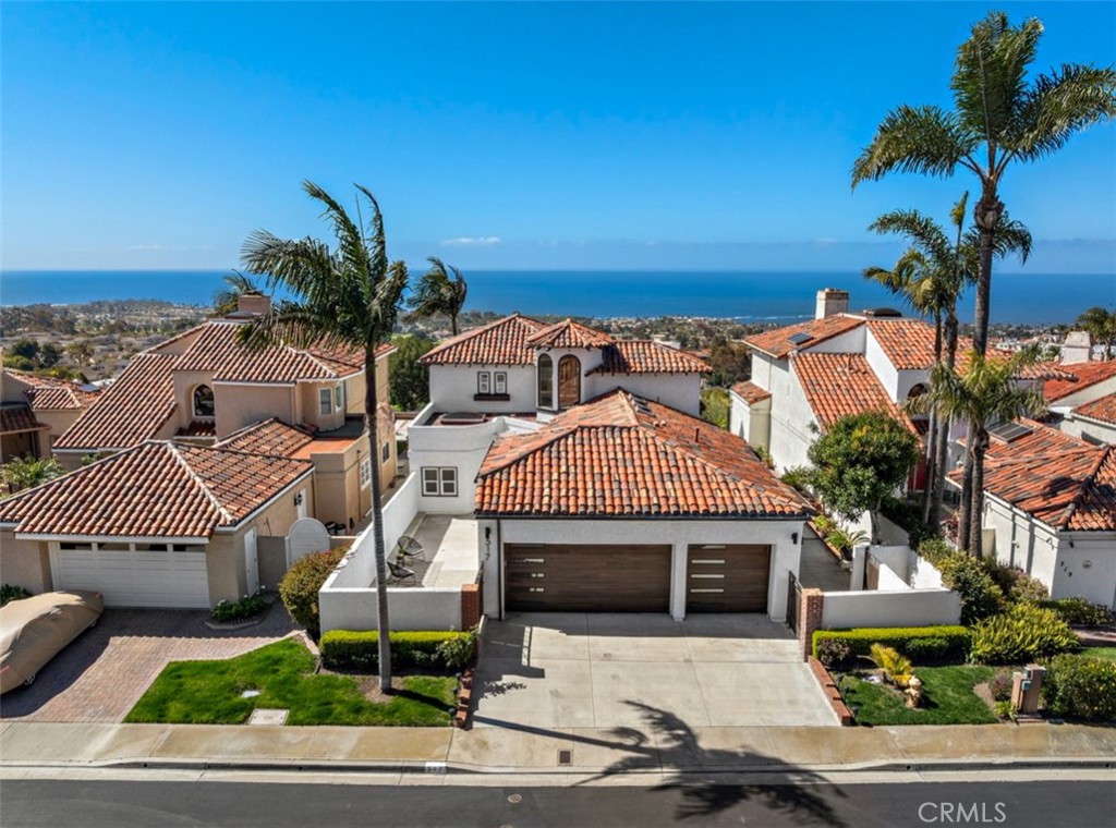 Enjoy breathtaking ocean views, serene sunsets, and unparalleled privacy at 517 Avenida del Verdor in San Clemente. Perfectly positioned on a rare single-loaded street in a peaceful neighborhood, this home offers unobstructed ocean vistas and the tranquility of having no homes directly across—an incredibly hard-to-find combination in coastal living. One of the few properties in the area to also feature a full three-car garage, it pairs everyday convenience with standout curb appeal. Originally built in 1980 and fully reimagined in 2017, this home merges modern design with exceptional craftsmanship. Inside, you’ll find four luxurious full baths, an open-concept layout with newly installed hardwood floors, a chef’s kitchen with high-end appliances, custom cabinetry, and striking countertops. Each bathroom showcases premium finishes, with three walk-in showers and one soaking tub, while modern, dimmable recessed LED lighting sets the ideal ambiance. The garage is finished with high-end epoxy flooring and new heavy-duty doors. Step outside to a remodeled outdoor kitchen with granite countertops, a stainless steel sink, and a gas line hookup—perfect for entertaining. All three upstairs bedrooms offer sweeping 180-degree views of the Pacific Ocean, San Clemente Golf Course, rolling hills, and glittering city lights. Unlike many view homes that fade after sunset, this location continues to impress well into the evening. Its elevated position offers unmatched privacy with no freeway visibility. Recent upgrades include a full exterior repaint with Sherwin-Williams SuperPaint, new wooden side gates, and energy-efficient LED exterior lighting. In 2025, the roof was refreshed with new tiles and skylights to enhance natural light and durability. Situated in a quiet HOA that provides front yard landscaping and weekly backyard maintenance, this move-in-ready home offers a rare blend of luxury, peace, and thoughtful design—truly the best of San Clemente, day or night.