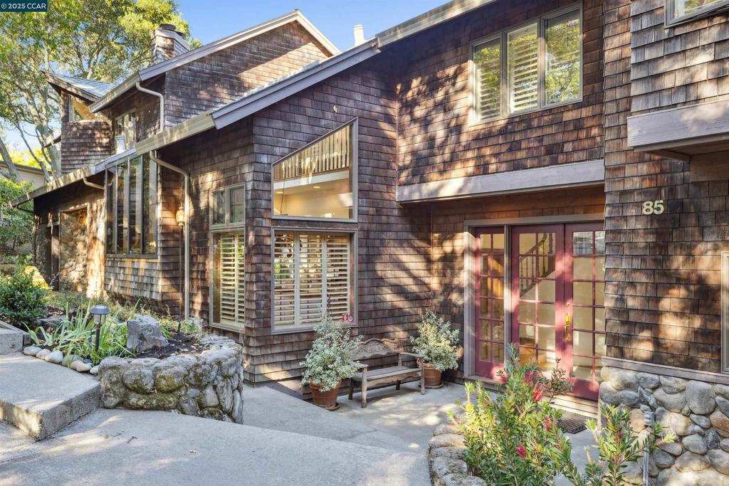 Nestled near the popular Orindawoods community and in the prestigious Orinda Country Club neighborhood, this beautifully appointed home offers a serene retreat with stunning views of the surrounding hills. As you enter, you’re welcomed by soaring ceilings, expansive windows, and a mix of rich hardwood floors and wool carpeting that immediately set a tone of understated luxury. Rich wood doors and millwork lend character and warmth throughout the home. A dream kitchen straight out of a Nancy Meyers movie sets the tone for this home’s heart and soul. Bathed in natural light pouring through a vaulted ceiling and dramatic skylight, the space is as charming as it is practical—a chef’s delight— equipped with professional-appliances and plenty of room to create. Just off the kitchen, the family room invites relaxation with its floor-to-ceiling rock fireplace and direct access to the backyard. A few steps away, an elevated pub-style bar offers a handsome setting for entertaining. A room meant for gathering—the formal dining room is a showstopper, with 17' ceilings and dramatic picture windows that flood the space with natural light. Outside, the grounds feel lush and alive. Mature vegetation surrounds you—citrus trees, hydrangeas, roses, and more—framing every path and corner in green.