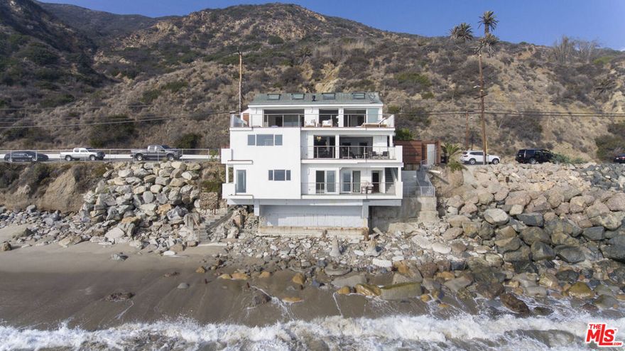 Nestled on the coveted east end of Malibu, this exquisitely remodeled beach house that comes fully furnished and fully stocked is a rare gem, offering a truly unparalleled living experience. Set against the backdrop of a serene, private sandy cove, this extraordinary property is the only residence in the area with no neighbors, ensuring total privacy and tranquility. The entry floor welcomes you into a sophisticated living space, showcasing impeccable finishes and a cozy fireplace. Expansive pocket sliding doors seamlessly blend the interior with the oceanfront patio, perfect for enjoying the stunning views. The adjacent dining room, with its captivating water vistas, leads to a chef's dream kitchen, adorned with high-end finishes and a striking floor-to-ceiling glass wine display.Upstairs, the master suite exudes luxury, complete with a beautifully designed bathroom featuring a freestanding tub and an expansive private deck with a built-in outdoor fireplace. A true sanctuary, this retreat offers a sense of serenity and unparalleled ocean views. The top floor also includes an additional bedroom, thoughtfully positioned to maximize the breathtaking views, and its own access to the vast deck.The lower level presents endless possibilities: a spacious second living room with a wet bar, a third bedroom directly on the water, and its own private oceanfront deck. This floor also offers the flexibility to serve as a separate studio, with its own entrance and a generous outdoor patio with panoramic ocean views.This beach house is one of Malibu's most unique and extraordinary opportunitiesa rare fusion of privacy, luxury, and exceptional design, all in one exceptional location.