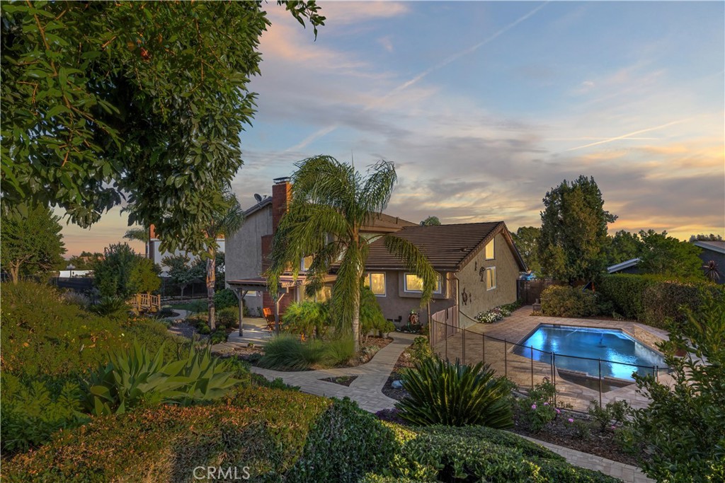 Hi, my name is 5830 Emerald St, But you can just call me Em. I've stood here since 1976 nestled at the end of this quiet cul-de-sac, where the mountains stand like old friends, greeting me each dawn with their timeless beauty. My four bedrooms have cradled so many dreams—especially the one downstairs with its own full bath. That room has hosted many guests who rave about the mountain views. It has seen quiet mornings and late-night secrets, always ready for whoever needs its comfort.
My kitchen, it’s the heart of me, upgraded with care and a clever appliance garage to keep the counters clear for life’s messes. I think back to a winter evening when the family gathered here, rolling dough for cookies, flour dusting their noses, and the warmth of their chatter wrapping around me. Out back, my pool and spa sparkle under the stars, set on nearly half an acre dotted with fruit trees— pomegranates, cherries, grapes, avocados, peaches and more. I remember a summer day when a little boy next door plucked his first avocado, eyes wide with pride. That yard has held picnics, parties, and quiet moments under the shade.
Upstairs, my primary bedroom opens to a balcony where the mountains feel close enough to touch. I’ve watched couples linger there, sipping coffee at sunrise and tea at sunset. I’m more than walls and windows; I’m a keeper of stories, longing to hold yours next. Come visit, and let’s weave new memories together. Love, EM