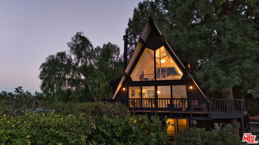 Welcome to Ravens Nest, an extraordinary A-frame masterpiece nestled among towering pines in the coveted Fernwood neighborhood of Topanga Canyon. With panoramic canyon views by day- and at night the gentle hooting of owls under star-filled skies, this home is a haven for writers, creatives, nature lovers, and anyone seeking peace, privacy, inspiration and wellbeing. As you approach, the striking silhouette of the A-frame draws you inbold yet harmonious with its forested surroundings. Inside, soaring ceilings and a dramatic two-story wall of glass flood the home with natural light and seamlessly frame breathtaking vistas. Every room invites the outside in: whether you're doing your morning yoga on the wrap around deck or writing your next great novel as hawks glide by outside your window, the connection to nature is ever-present. The open-concept living area blends effortlessly with the outdoors, making it as ideal for quiet mornings as it is for vibrant gatherings. The kitchen, dining, and living areas flow together beneath vaulted beams, grounded by rustic textures and contemporary finishes. Three tranquil bedrooms each offer unique outlooks on the surrounding landscape, while both bathrooms are tastefully designed with modern fixtures, offering a perfect blend of style and comfort. Outside, multiple decks invite you to bask in the quiet beauty of canyon lifewatch the sun rise, count stars at night, or simply exhale beneath the pines.A double carport and lush, mature, terraced landscaping enhances privacy and serenity, creating the feeling of a private mountain retreat and invites room for expansion to add decks, a spa and possibly a lap pool. With many hiking trails on your doorstep and just minutes to the heart of Topanga with its vibrant community life, farmers market, and artisan shops and just a short drive to the westside or the beach, Ravens Nest is more than a home, it's a lifestyle.