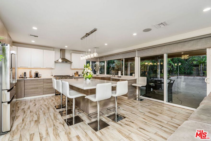 Welcome to this beautifully remodeled gem located south of the Boulevard in Tarzana. From the moment you arrive, you'll be drawn in by the stunning curb appeal, lush landscaping, and soaring palm trees that frame the entrance. Inside this spacious home offers 4 bedrooms and 4 bathrooms, with an open-concept layout designed for both everyday living and entertaining. The gourmet kitchen features top-of-the-line appliances, a massive center island, and a farmhouse sink with views of the covered patio and backyard. Downstairs, you'll find a second family room complete with a built-in bar, a stylish full bathroom, and a converted garage offering a kitchenette, custom cabinetry, a separate bedroom, and a dedicated laundry room, ideal for guests or extended family. Upstairs, the oversized primary suite boasts a private balcony, walk-in closet and double sink master shower, accompanied by two additional bedrooms. With multiple living areas, a resort like pool, and all the upgrades throughout, this is a home you don't want to miss. This is a true entertainer's home and move-in ready. This home is equipped with low energy solar panels, just imagine how much you will save each month on your electricity bills. Come see it before it's gone! Property is also being offered partially furnished.