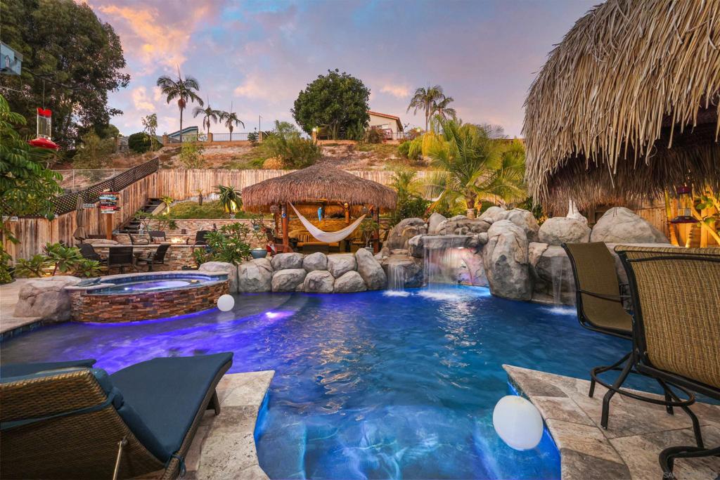 Welcome to your suburban paradise! This beautiful 6-bedroom, 3.5-bath home is the perfect retreat, offering resort-style living in the peaceful Tierrasanta neighborhood. Designed for comfort and connection, the home features multiple living areas, a remodeled kitchen with granite countertops and top-of-the-line appliances, and a spacious dining area. Step outside and discover the true highlight: a multi-level backyard oasis complete with a heated pool, waterfalls, hot tub, outdoor TVs, a BBQ and smoker. It’s the kind of space where memories are made and relaxation comes easy. Enjoy modern energy efficiency with an owned solar system and dual-pane windows throughout, helping to keep the home cool and utility costs down. Just a short distance from countless shopping and dining options, this home keeps you close to all the action—while offering the perfect place to unwind.