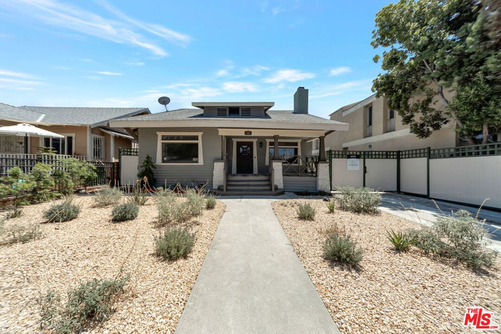 Stunning 3 Bedroom 3 Bath 1909 Craftsman Style home beautifully blends Historic Vintage Charm with Modern Amenities, Recently Completely Remodeled and Lovingly Restored, it is Located in the Heart of Jefferson Park HPOZ. The front Exterior is complete with original windows and doors. Enter into the expansive living and dining rooms and embrace the original built-ins, stained glass and coffered ceilings. Updated with all new engineered wood floors, recessed lighting and Vintage inspired touches. The front bedroom is color drenched with original windows, doors and moldings. Through the classic statement dining room, enter the all new, completely remodeled Modern kitchen. Custom White Oak cabinetry with a natural wood finish, soft close drawers, brand new appliances and farm style sink. Gorgeous all natural quartzite counter tops and shiplap backsplashes. The oversized center island has electrical outlets and room for bar stool seating. A wine collectors dream, it has one whole wall of wine racks! Behind the beautiful wall of cabinetry, doors slide back and open to the hidden Appliance Garage. Here you are equipped with all the small appliance capacity and coffee bar counter space necessary with multiple cabinets to store and arrange all your entertaining treasures. The storage space, pantry and special cabinet pullouts are not to be outdone in this well planned Gourmet Kitchen. Adjacent to the kitchen is a stylish Mudroom meets laundry space, the most adorable powder room, wallpaper tiles and a color theme matched to the blue and white penny tile flooring. The Center Hall plan takes you down the wood paneled hallway to the Primary Suite. Almost in it's own wing, there is a large walk-in closet with a secret storage area. This spacious room is light and bright and the Primary Bath weaves a vintage inspired Claw foot tub with a modern walk-in shower. Gorgeous gold accents abound with free standing console style Cararra Marble countertop sinks and a Crystal Chandelier. All this surrounded by classic bead board walls. Back to that Mudroom... exit outside to a sprawling, fully fenced yard newly landscaped with an irrigation system, pea gravel and checkered style pavers. Enjoy the charming converted Carriage House ready to be made into an ADU. The home is complete with A/C, Solar Panels and Tankless water heater. The long driveway would fit two cars behind the gate and one in the front. This remarkable home is a Must SEE!!