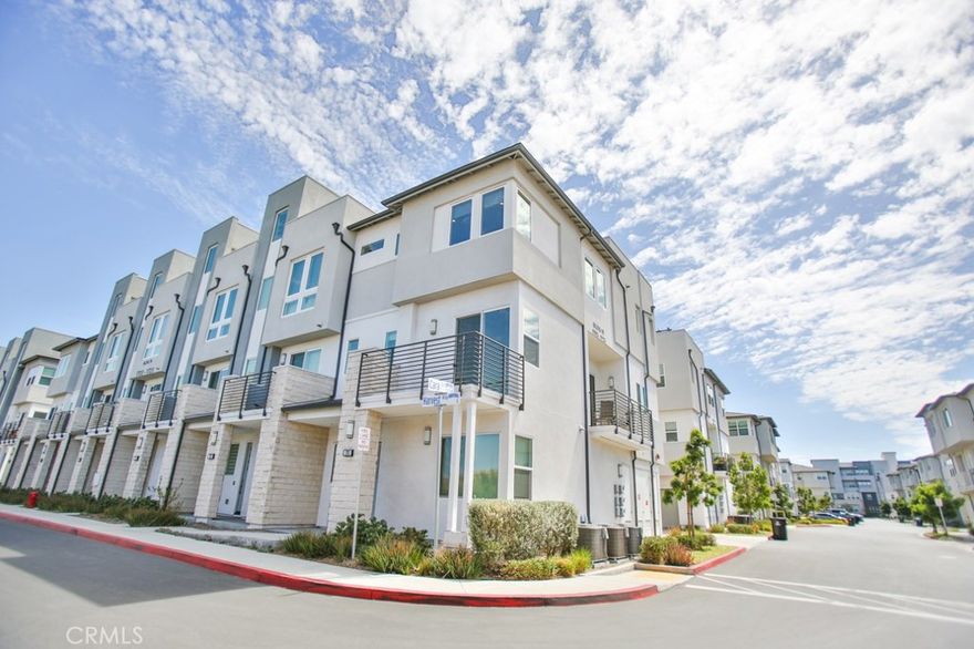 Welcome to your new home in the highly sought-after 100 West gated community in Anaheim! This beautifully designed 3-story end-unit townhouse features 4 spacious bedrooms and 3.5 bathrooms, offering a bright and open layout with upscale finishes. Ascend to the second floor to discover an expansive open concept living area adorned with rich dark brown vinyl flooring, plush carpeting, recessed LED lighting, and custom paint. The chef-inspired kitchen is a masterpiece, showcasing beautiful white Shaker cabinets, gleaming granite countertops with a full backsplash, premium Whirlpool stainless steel appliances, and a spacious center island perfect for casual dining. More conveniences with inside laundry room. Two private balconies, and a rooftop deck with views of Disneyland fireworks every night perfect for relaxing or entertaining. Perfectly positioned just minutes from Anaheim's finest attractions (The Packing House, Disneyland, Honda Center, Angel Stadium, and premier shopping.)