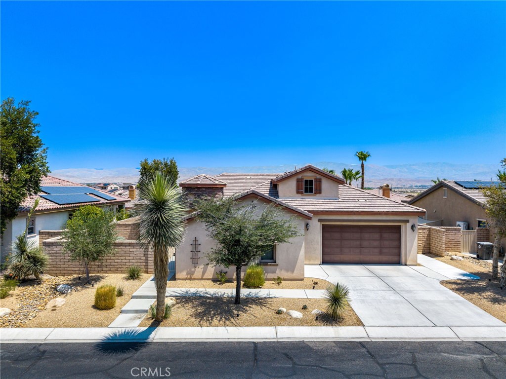 Located in the desirable community of The Gallery in Palm Desert, this 4 bedroom, 3.5 bath home offers 2,596 sq. ft. of stylish living space. A gated courtyard entry leads to an elegant rotunda, high windows, and 12 ft. tray ceilings that fill the home with light. The formal dining room is perfect for entertaining, while the kitchen boasts black granite counters, double ovens, and a Sub-Zero built-in refrigerator. The fourth bedroom is currently used as an office with a walk-in closet for added storage. The home is powered by 40 solar panels and a Tesla back up battery that are paid off. Enjoy resort-style outdoor living with a covered patio featuring recessed lighting and a mist system, plus a Pebble Tec pool with tanning shelf. The private backyard offers low-maintenance landscaping and stunning mountain views. Two attached garages accommodate three cars. This home blends elegance, comfort, and function in one of Palm Desert’s most sought-after neighborhoods.