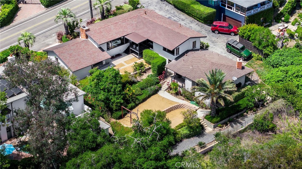 Embrace the serenity of this ranch-style coastal retreat boasting breathtaking ocean, coastline, and mountain views. This expansive property, featuring a 4-bedroom, 4-bath home with 2,500 square feet of living space on a nearly 10,000 square foot lot, offers endless possibilities. Envision adding a pool, expanding the existing structure, or creating a guest house. The living areas present stunning views of Main Beach to the north and captivating ocean and mountain vistas to the south. The home has been tastefully upgraded with a modern kitchen, stylish bathrooms, new flooring, fresh interior paint, and the addition of a fourth bedroom and bath. Seize the opportunity to further enhance your own Laguna compound and enjoy coastal living at its finest.
