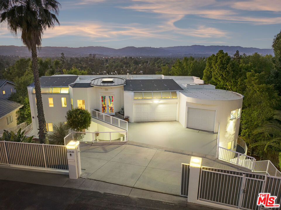 Architectural Elegance with Income Potential & Breathtaking Views. Tucked just south of Ventura Boulevard, this distinctive estate combines modern sophistication, privacy, and exceptional versatility framed by sweeping mountain vistas. The main home offers 3 bedrooms and 3.5 baths in a light-filled, contemporary design. A dramatic central staircase connects open living spaces with soaring ceilings, skylights, and refined finishes. The living room, featuring a fireplace and wet bar, sets the stage for gatherings, while the formal dining room and gourmet kitchen, with granite counters and stainless steel appliances, cater to everyday living and entertaining alike. Upstairs, the serene primary suite provides a true retreat, featuring a fireplace, spa-inspired bath, and walk-in closet. Two additional ensuite bedrooms open to private balconies, and a versatile loft adds flexible living space. Enhancing the property's appeal are 6 further bedrooms with private entrances and kitchen or kitchenette amenities, currently leased (though can be delivered vacant), providing excellent income potential while maintaining privacy for the owner. Opportunities abound, including the possibility of an SB9 lot split for future development. With its blend of elegance, comfort, and financial upside, this residence is ideal as a luxurious primary home, an investment property, or both. Situated near top-tier dining, shopping, and amenities, this rare Oak Park offering delivers the best of Southern California living.