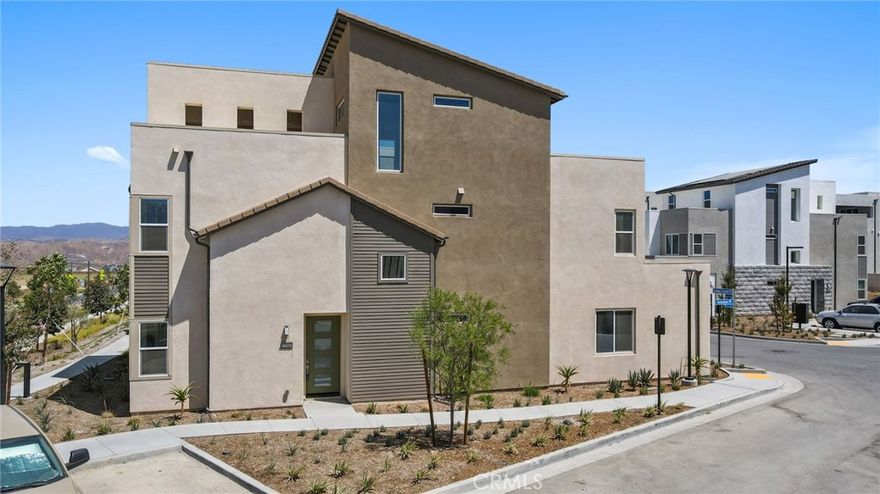 Welcome to modern luxury in the heart of Five Point Valencia. This stunning Lennar Rosemist Plan 4, the largest and most desirable model in the community, was completed a couple years ago and offers the perfect blend of sophistication, comfort, and style. With five bedrooms, four and a half bathrooms, and three spacious levels, this home showcases impeccable design and attention to detail. The main floor features an open-concept, dining area, and chef’s kitchen with a large quartz-topped island, professional-grade stainless steel appliances, and a six-burner cooktop with designer hood. Ten-foot ceilings and wood-like LVP flooring create a sense of warmth and grandeur throughout. A guest bedroom with a full bath on the first floor provides flexibility for visitors, extended family, or a home office. Upstairs, the luxurious primary suite offers a peaceful retreat with a spacious walk-in closet, dual vanities, soaking tub, and separate shower, while three additional bedrooms, two more baths, and a laundry room complete the second floor. The top level is a versatile bonus/loft area featuring its own bathroom, wine fridge, counter space, and a covered terrace with panoramic views of the Santa Clarita Valley—perfect for a game room, gym, or lounge. Enjoy year-round outdoor living with a gated backyard and covered patio ideal for dining or relaxing. Located within the vibrant Five Point community, residents have access to world-class amenities including three pools, a spa, BBQ areas, playgrounds, scenic greenbelts, and a resort-style clubhouse. Conveniently close to shopping, restaurants, top-rated schools, Magic Mountain, and freeway access, this like-new home offers the best of modern design and community living in one of Valencia’s most desirable neighborhoods.