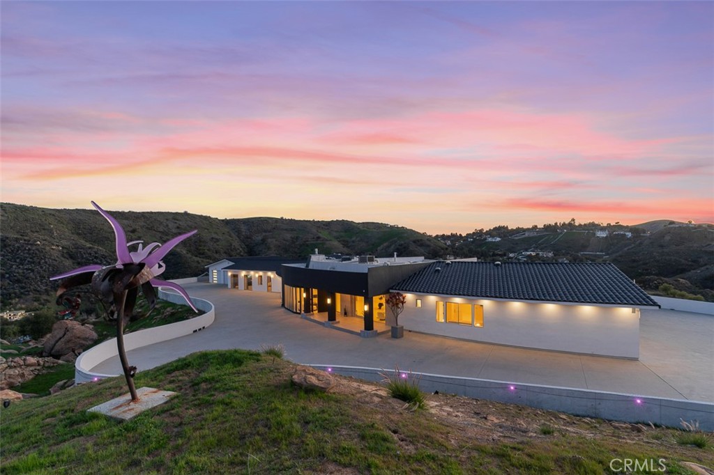 Discover the pinnacle of luxury living in this 2020-built, single-story modern estate, situated on over 31 private acres in the prestigious guard-gated community of Bell Canyon. Accessed via a triple-gated entry and a quarter-mile private driveway, this architectural masterpiece offers unobstructed 360-degree mountain vistas, ensuring both serenity and seclusion.
As one of the most coveted properties in Bell Canyon, this estate boasts 5 spacious bedrooms and 5.5 opulent bathrooms across 6,751 square feet of meticulously designed living space. Constructed with steel framing, copper plumbing, and premium insulation, the home exemplifies quality and durability.
Inside, wide plank oak flooring and Italian 48x48 Imola tiles complement soaring ceilings and solid core doors adorned with EMTEK chrome hardware. The state-of-the-art chef's kitchen features a massive center island, mother-of-pearl backsplash, Thermador appliances, and a 16-foot buffet—perfect for entertaining.
Every room is bathed in natural light, offering breathtaking mountain views. Additional amenities include a media/ballroom, game room, and an entertainer's wet bar. The grand primary suite offers seamless indoor/outdoor living, an all-stone spa-like bath, and a 370-square-foot walk-in closet.
The estate's expansive grounds feature large flat areas ideal for equestrian pursuits or recreational activities. Bell Canyon's Class-A equestrian facility accommodates over 75 horses and is open to both residents and non-residents. Community amenities include parks, hiking trails, pickleball and tennis courts, playgrounds, a residents' gym, and organized events for all ages. Located within the award-winning Las Virgenes School District, with convenient access to freeways, beaches, shopping, dining, Calabasas, and Hidden Hills.
This home is also available for rent. Don't miss the opportunity to own or lease this exceptional property. Schedule your private tour today.