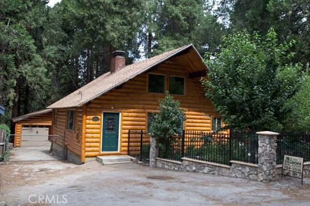 Beautiful Half Log sided home boasts so much! Enter into large living room with soaring ceilings and a knotty Pine wall of book cases for your treasured possessions. Dual sided fireplace has efficient wood burning stove on one side and open fireplace on the other. Kitchen opens into living room with counter open to living room. Main floor master suite with full bath has own entry. Upstairs is charming smaller bedroom, and an open loft area divided by a half bath and large closet. Big rear deck looks out on backyard and detached two car garage. Property cross fenced with plenty of off street parking.