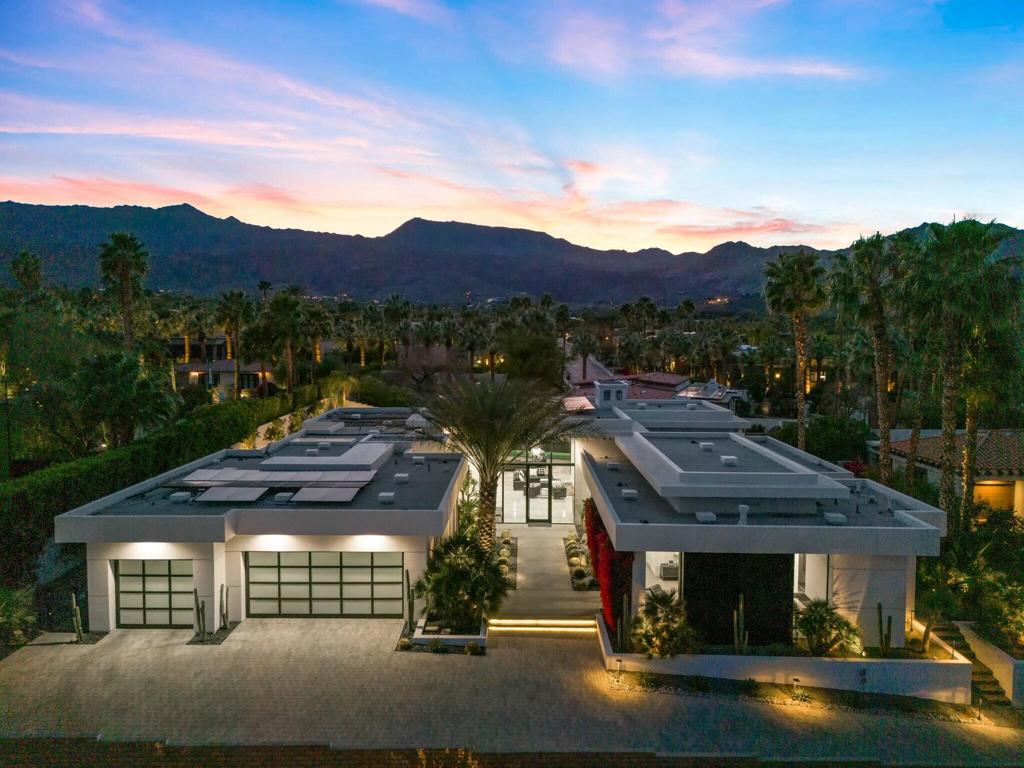 Situated on a near half-acre lot with complete privacy. This custom home in the Highlands, backs onto the iconic Bing Crosby Estate. As you drive up a palm tree lined, well landscaped entrance, you will press a button to open your motorized gates and enter your oasis. Walk towards the front door to a 15ft all glass entry with beautiful, mature landscaping on each side. Enter the home and you will see 15ft ceilings, a 25ft motorized pocket door, 10ft wide custom isokern fireplace, a well-positioned wet bar with seating for 4. To your left is a beautiful custom kitchen with Wolf/Sub Zero Appliances, a new custom hood, and new natural stone slabs on the back wall, and a nice view of Eisenhower Peak from the sofa. Flooring inside and out is a soft contemporary marble, and interior doors are full height, floor to ceiling. Two Master Suites (one with separate entrance to be an optional casita), with secondary bedrooms en-suited and large enough for king beds. Large, luxurious master bathroom with his and hers water closets, large walk-in closet, and soaker tub. 1200ft covered patio with built-in heaters, fans, misters, multiple seating areas, fire pit and built in barbecue with sink, fridge and outdoor motorized shades to close in the outdoor area. Large side yard with room for a dog run, bocce, putting green, and or your favorite activity! Very large garage with A/C, and built in shop vacuum. Large enough to hold 3 cars/trucks plus 2 golf carts, plenty of storage cabinets and a separate storage room. 39 owned solar panels for the house and owned pool solar to save heating costs for the 60' lap pool and 10' spa. Landscaping has been upgraded with the addition of dramatic entrance with Date Palms, polished black rock, smoked mirrors, cacti and desert landscaping, keeping water bills efficient. Furnishings, art and accessories available outside of escrow. Whether you are entertainers or just want complete privacy, this is a good one!!