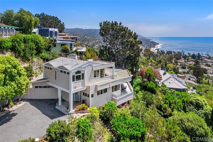 Perched within the gated enclave of Allview Terrace, this rare offering captures the very best of Laguna Beach living — sweeping ocean, coastline, and hillside views paired with privacy and seclusion, all while being just moments from downtown and the beach.  A long, private driveway sets the stage for this special residence, creating a sense of arrival and exclusivity. Upon entry, you’re greeted by expansive living spaces oriented to take in 280° views stretching from the southern coastline and Hotel Laguna to Catalina Island, North Laguna, Shaw’s Cove, and the green hills of the Dartmoor Hiking Trail.  Walls of Andersen windows and oversized sliding glass doors flood the interiors with light and seamlessly connect to spacious view decks — perfect for entertaining or simply enjoying Laguna’s famed sunsets beneath the silhouette of a Torrey pine.  The main living area features wood flooring, a centerpiece fireplace with a custom mantle, and a wet bar, while the adjacent dining area and kitchen are designed to maximize the panoramic setting.  A powder room and laundry are also on this level.  The cozy library/den, complete with floor to ceiling built-in shelving, fireplace and skylight, offers a quiet retreat for reading or work.  Two en-suite bedrooms are located on the main level — one with French windows and doors opening to balcony deck and ocean views, the other with a skylight and full bath.  Upstairs, the primary suite provides a private sanctuary with vaulted ceilings, a viewing deck over North Laguna, walk-in closet, and a spa-like bath featuring dual sinks, a soaking Jacuzzi tub, walk-in shower, and private water closet.  A bonus office/den area completes this upper retreat.  Set on an oversized lot with mature coastal landscaping and adjacent to the historic Hortense Miller Garden, the property also offers a two-car garage and parking for up to six additional vehicles.  



22691 Allview Terrace is a rare combination of dramatic views, privacy, and security — part of a gated enclave of only 32 homes with controlled-access access — all while being just minutes from downtown Laguna Beach, local beaches, shopping and restaurants.