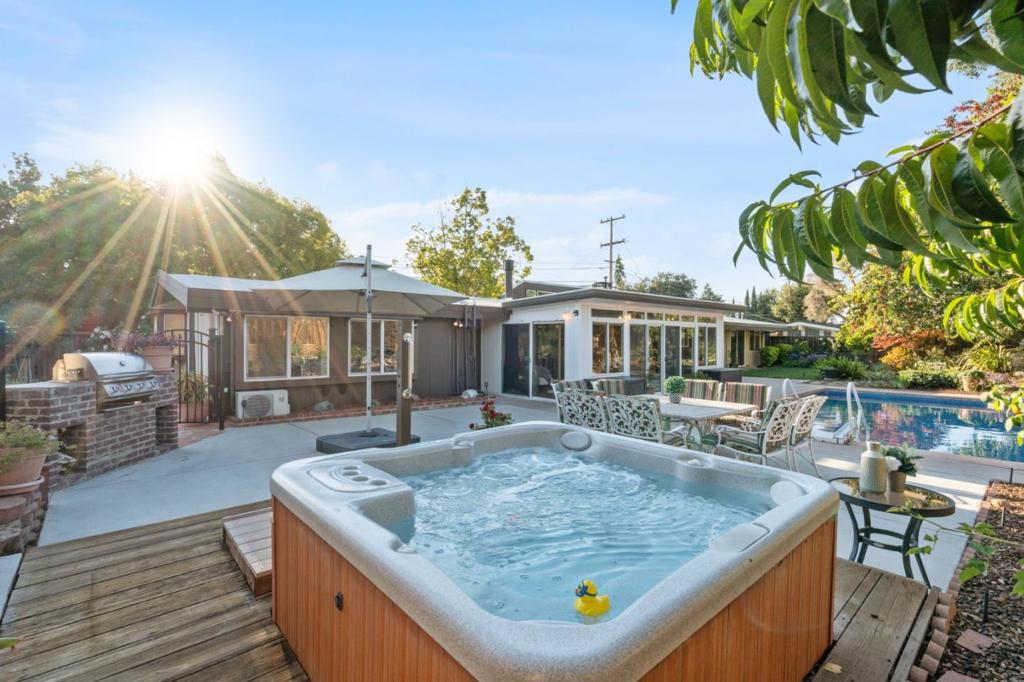 A RARE architectural gem, 814 Gail Avenue is a Refreshed Eichler mid-century modern home set on a beautifully landscaped 10,087 sq ft corner lot in the heart of Sunnyvale. Expanded single-level residence offers 2,234 + sq ft of timeless style, clean lines, & modern sophistication perfectly merging mid-century charm with 2025 design. Iconic floor-to-ceiling glass, radiant heated floors, and seamless indoor-outdoor flow define the airy layout. Main living room features a sleek modern fireplace, while the oversized family room adds a 2nd fireplace offering multiple warm & welcoming spaces for entertaining or quiet relaxation. An expansive primary suite is a true retreat, with peaceful backyard views and a flexible sitting area ideal for a home office. The sun-drenched enclosed sunroom opens to the backyard oasis, where a sparkling pool and spa are framed by mature fruit trees, blooming gardens, Junior ADU, 2 storage sheds, and a large raised vegetable bed. Fully fenced front and back yards offer complete privacy. Gated side entrance leads to a 305 sq ft J-ADU with its own private entry ideal for guests, extended family, or rental income. Blending iconic Eichler architecture, stylish upgrades, & lush outdoor living, this distinctive home delivers the ultimate in California living.