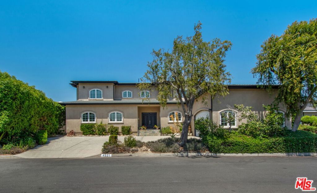 Make sure to watch the virtually staged video and enjoy this amazing opportunity set in the prestigious hills of Baldwin Hills Estates, this palatial 4,000 sq ft custom designed and built residence offering three bedrooms plus a versatile library/retreat that could serve as a fourth bedroom and four baths. This home was re-imaged and issued a Certificate of Occupancy in 2010 - (assessor's records show 3 bedroom 4 bath). A semi-circular driveway and an attached two-car garage set the tone for elegance and privacy for a home set back from the street on a quiet short street in Baldwin Hills.. The finished garage that has loads of natural light through windows that make it prime to serve as a junior ADU with moderate conversions.. Beyond the solid wood double doors, an expansive open floor plan unfolds with soaring ceilings, recessed lighting, and exceptional flow for both everyday living and grand-scale entertaining. The formal dining area connects seamlessly to a spacious living room though separated by a single side fireplace set in an impressive stone wall that defines the living room from the dining area without closing the rooms in. Enjoy a chef's kitchen with all-wood flooring that flows seamlessly throughout the living and dining areas with fully upgraded solid wood cabinetry, a large center island, stainless steel KitchenAid appliances include a double oven with convection and warming drawer, five-burner cooktop, a dishwasher, a double-door refrigerator, pantry storage, and more. Complimenting the kitchen is a separate breakfast room with high ceilings, recessed lights and a separate laundry room and powder room. An expansive family room runs the entire length of the lower level and is perfectly located parallel to the living and dining rooms. The family room has recessed lighting and dual ceiling fans to accompany the whole house heating and air conditioning systems. Bringing the outdoor-indoor living style the family room boasts a wall of windows which along with a sliding glass door opens to the backyard. Besides tremendous entertaining space, the lower level also has a private wing where it hosts a luxurious guest suite and a well-appointed three-quarter bath AND a lower-level primary suite that offers privacy, custom storage, and an en suite full bath with a dual-sink vanity and tub/shower combination. Ascend the sweeping semi-circular staircase to a dramatic landing overlooking the living room, leading first to the three-room library/office retreat once used by an iconic Los Angeles ambassador for peace and justice complete with custom floor-to-ceiling built-ins shelving, cabinetry and desk this elegant three room owner's retreat also has a private office. The crowning jewel of the second level is the grand primary suite, a serene and expansive personal oasis with two giant walk-in closets that have customized interiors including a private dressing area, crossing this grand scale bedroom to a corner window you will enjoy a spectacular view of the breathtaking Los Angeles skyline, BMO Stadium, Exposition Park, the Baldwin Hills mountain ridge line , and swaying California palms.. Warmth and elegance are exuded by the fireplace in this suite and you can retire to relax in a spa-inspired bath featuring a jetted soaking tub, double vanity, walk-in shower with built-in bench and stylist architectural design. Outdoors, the expansive backyard offers both privacy and possibility, with a separate patio and lush grassy area ideal for entertaining or peaceful retreat. Known for its panoramic city and mountain views, Baldwin Hills Estates is one of Los Angeles' most desirable enclaves offering a sense of community, proximity to the best of the city, and the rare combination of serenity and accessibility. VIRTUALLY STAGED PHOTOS AND VIDEO to help you see the incredible opportunity more clearly!