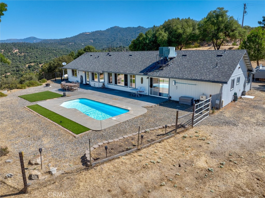Impressive amenities in this light and bright home with an open floor plan! This spacious residence features 4 bedrooms, 3 bathrooms plus there is an expansive bonus room featuring built-in cabinetry and a convenient Murphy bed, ideal for hobbies and extra guests. The mountain views from the large windows are stunning and you can also enjoy them from the refreshing and sparkling swimming pool. The property also overlooks the 400 acre Ahwahnee Hills Regional Park, a close recreation option. Beyond the 2-car garage, you'll find an additional 520 square foot garage, providing space for a workshop or extra parking. The well-maintained grounds feature a paved driveway, covered RV parking, and an additional carport. All of this and you are only about 23 miles to the Yosemite National Park entrance, perfect for frequent visits. Take a look at the photos and virtual tour to see why this could be the one you have been waiting for!