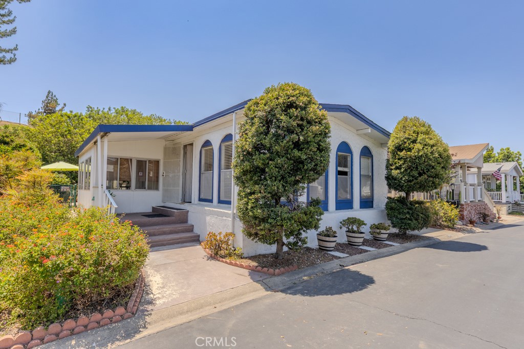 Welcome to 2851 Rolling Hills Dr #255 in Fullerton’s Cedarhill Estates, a resident-owned manufactured/mobile home community where you own the land. This property sits on one of the largest lots in the neighborhood, offering extra space on both sides and in the back with no neighbor directly behind, providing added privacy and outdoor space.
The heart of the home is the open floor plan that creates a true great room feel, where the family room, dining area, and kitchen all flow together as one expansive space. It’s ideal for both everyday living and entertaining. The kitchen includes a refrigerator, dishwasher, gas cooktop, built-in oven, range hood, and a bar-top island. Just off the great room is a screened-in porch that leads to a gated patio. While the main focus is the open layout, you also have a separate living room at the entry, offering a quiet space to unwind.
The spacious primary bedroom includes mirrored closet doors, built-in shelving, a sliding glass door that opens to the backyard patio, and a large en-suite bathroom with a soaking tub, walk-in shower, and generous vanity space. There’s an additional bedroom, a third room that can serve as an office or extra bedroom, and a remodeled three-quarter guest bathroom with a walk-in shower. The home also includes an interior laundry room with access to the covered carport, as well as central air and heating.
Cedarhill Estates offers resort-style living with amenities such as a pool, spa, clubhouse, gym, tennis and pickleball courts, billiards room, and RV storage. The community also hosts regular activities like bingo, dance classes, and bocce ball. Conveniently located near the Brea Mall, major freeways, top-rated schools, shopping, and dining, this home combines comfort, lifestyle, and location in one of Fullerton’s most desirable manufactured home communities.